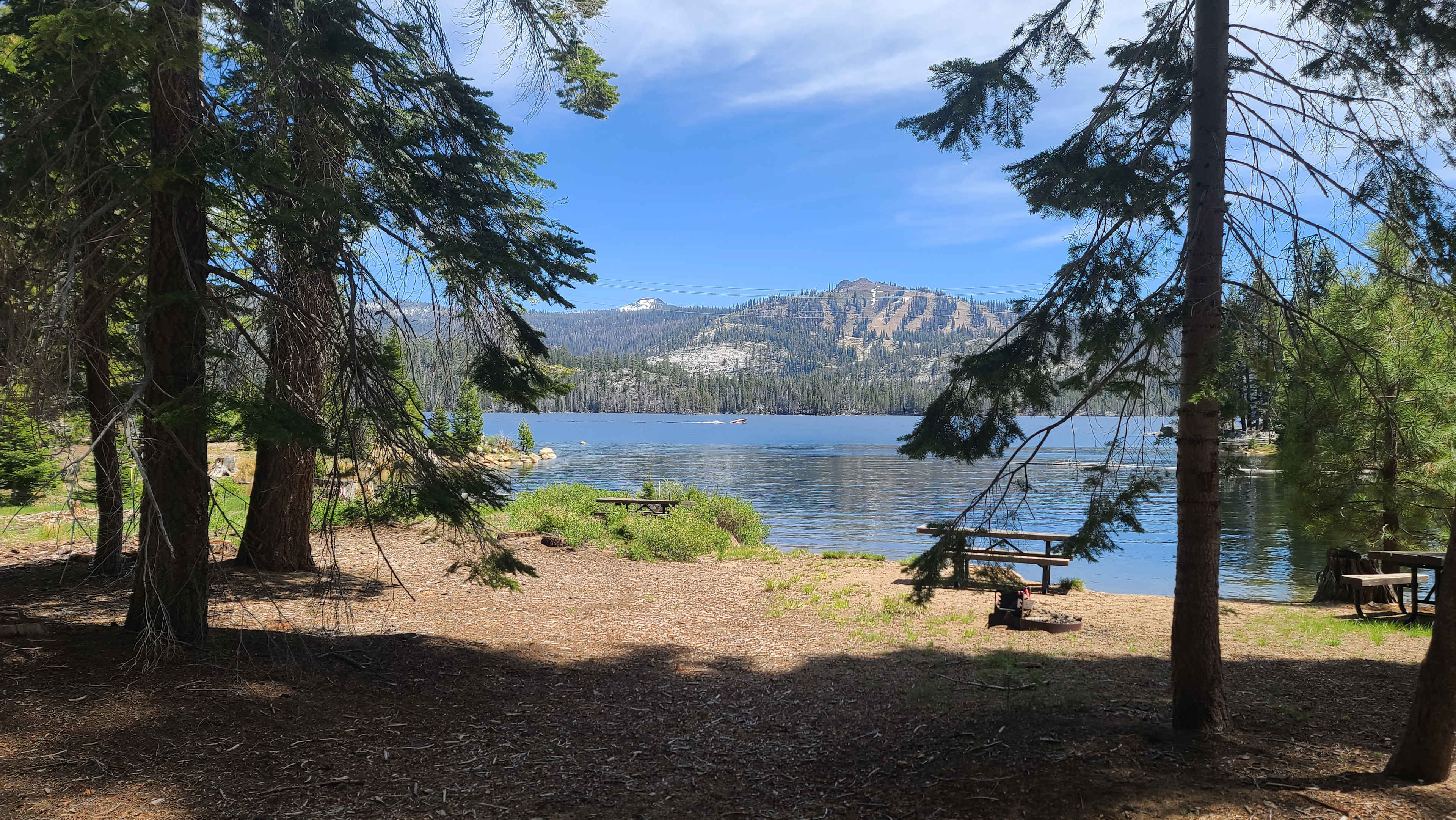 Picnic tables and tent camping by lake. 