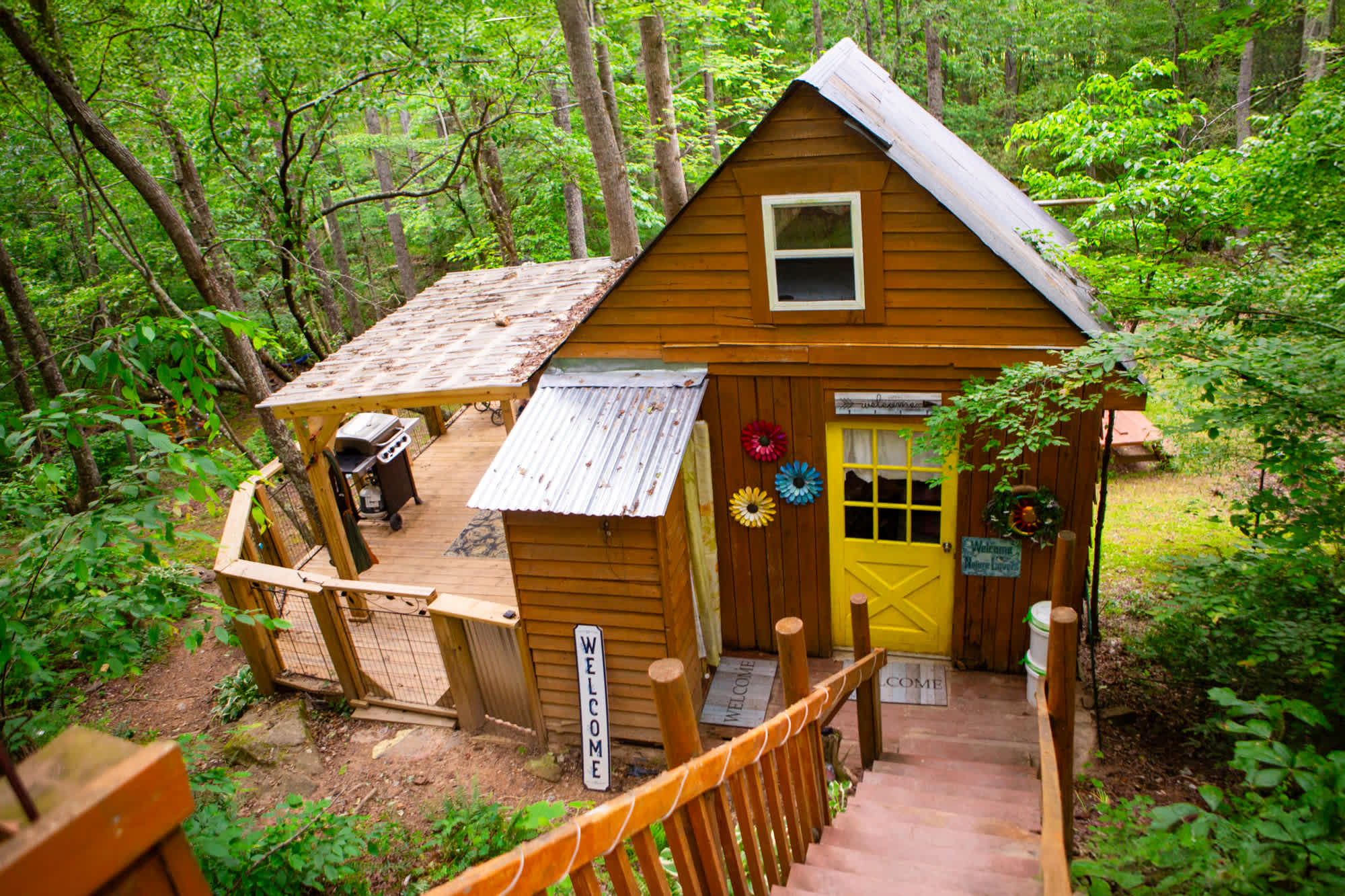 Cozy treehouse cabin, attached outhouse, and expansive wrap-around patio! 
