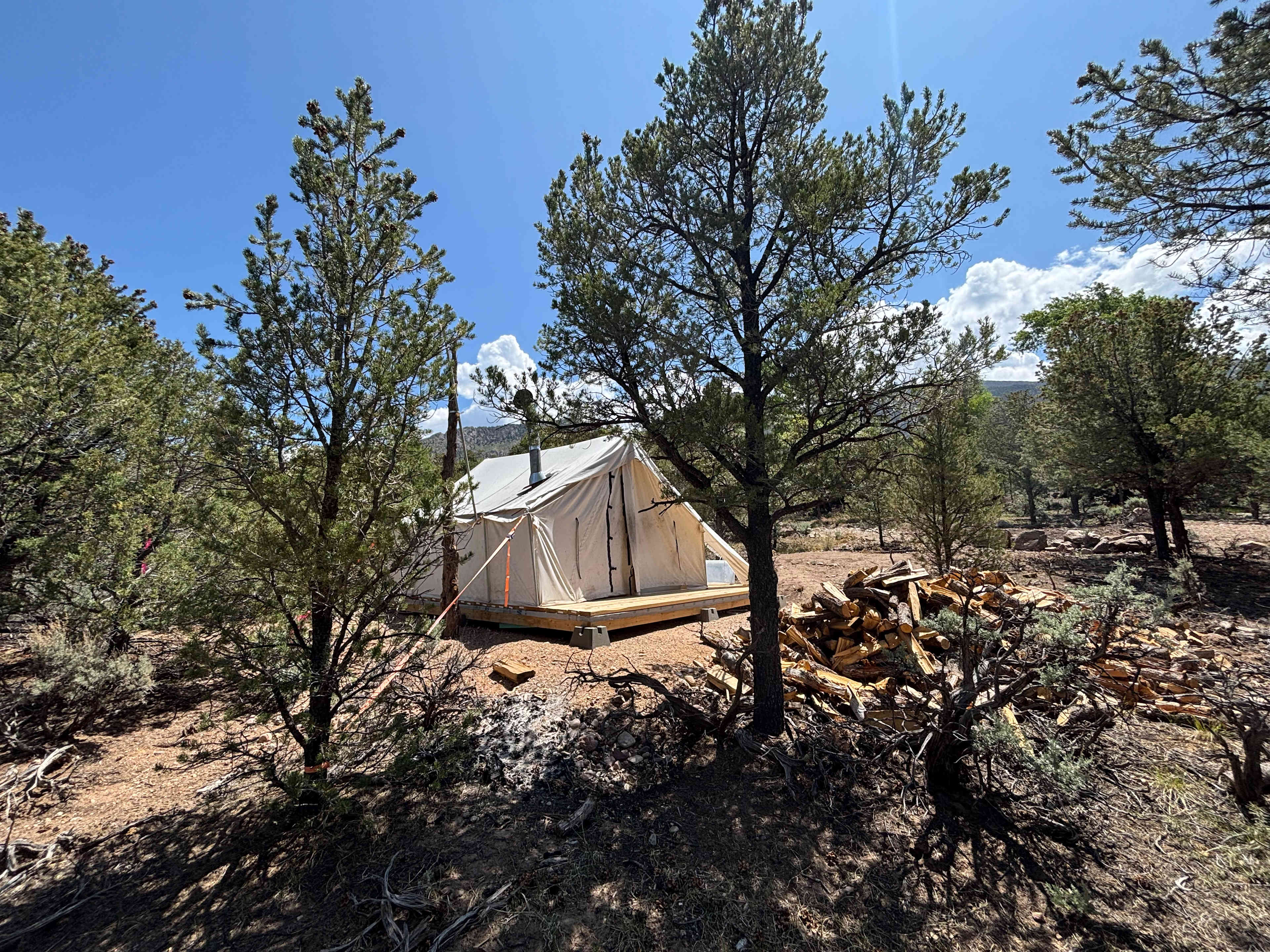 Our Mountain Outfitter's platform tent all set up for you with a comfy queen size air mattress, small wood stove, and plenty of wood to keep you warm