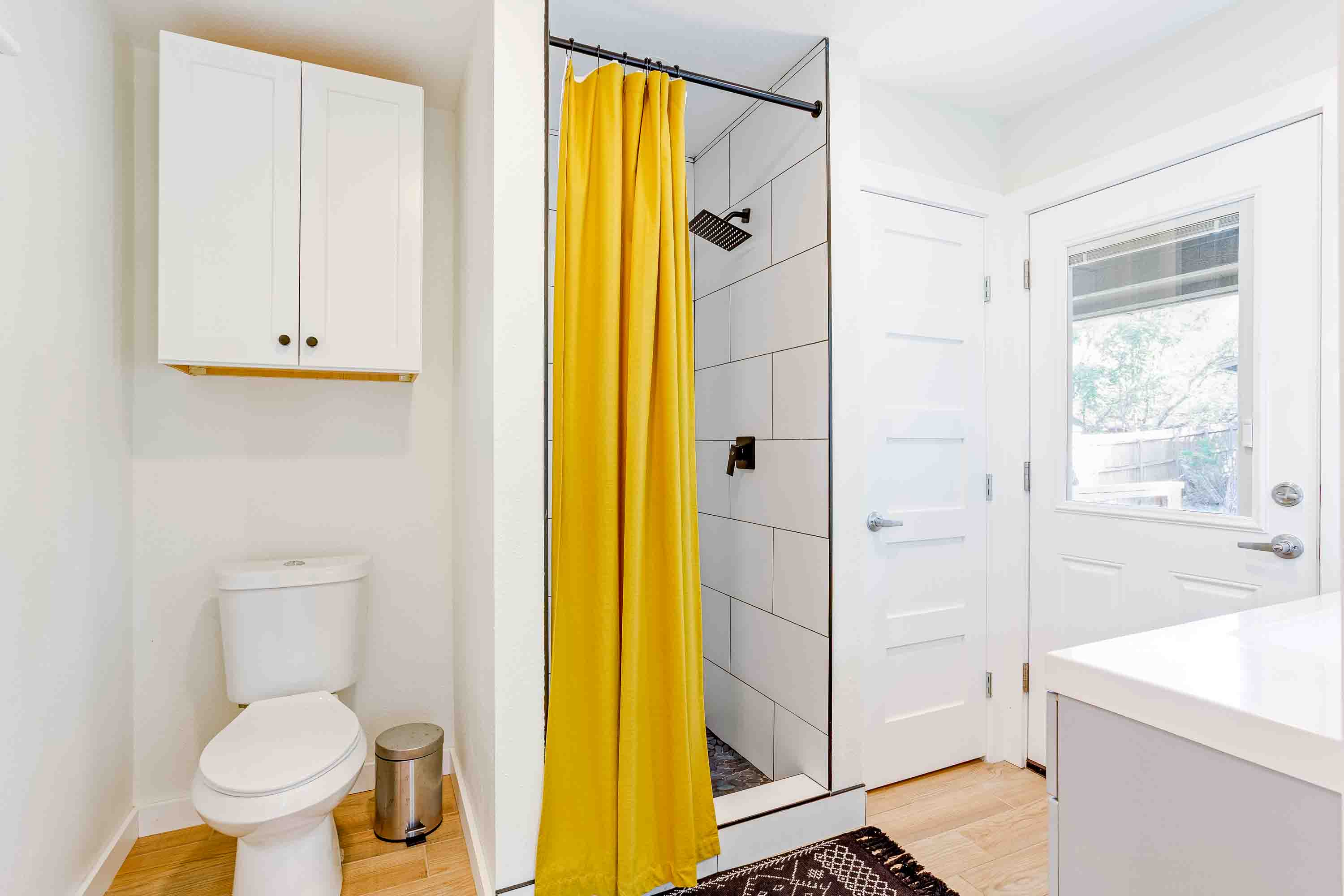 Bright and clean bathroom with a walk-in shower and easy access to the outdoors—everything you need for a comfortable stay.