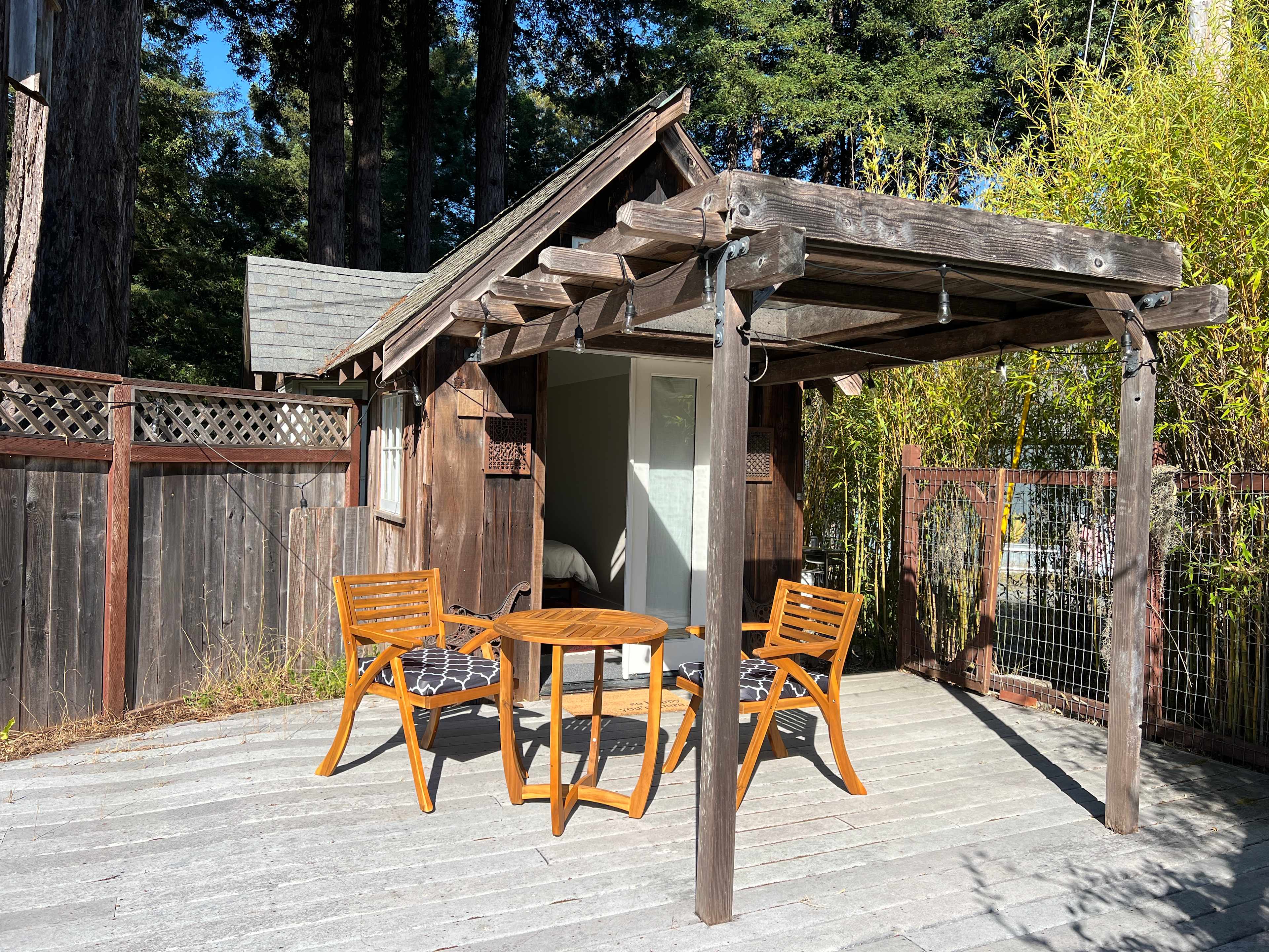 The deck of the Nest has a table and chairs and string lights.