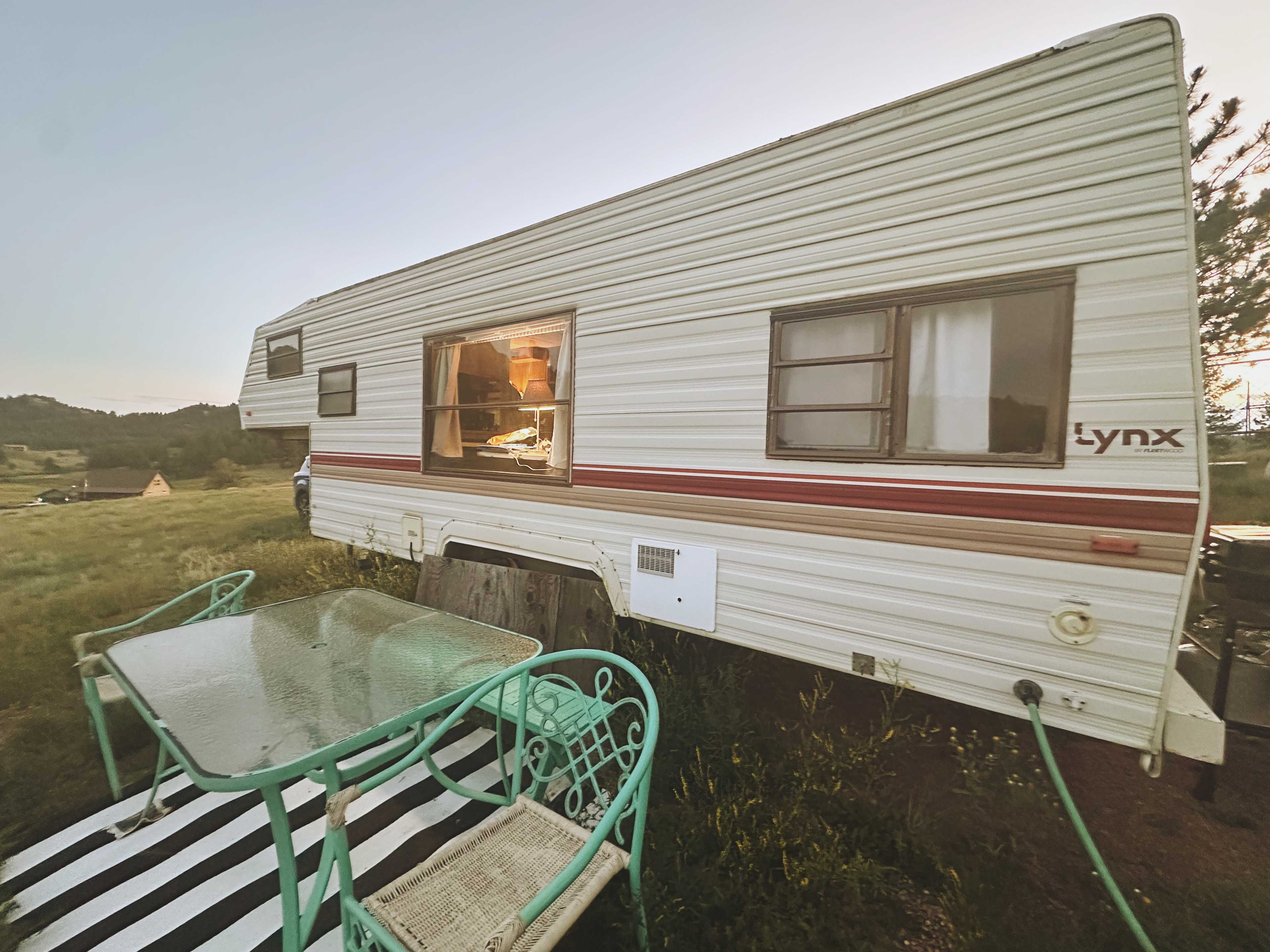 Private little seating area in front of the camper. It looks out toward the horses and rocks.