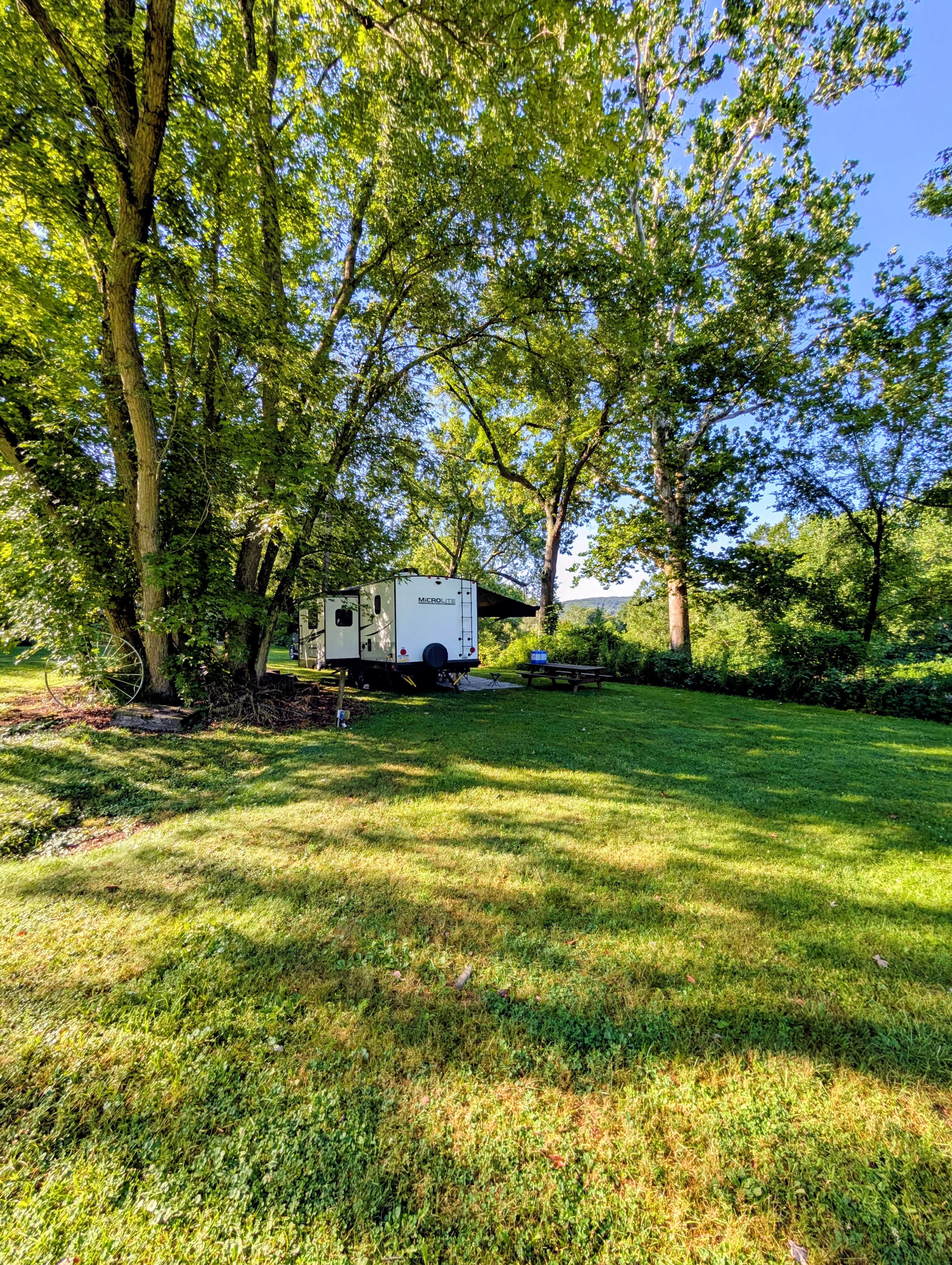 A view from the field of the campsite tucked under mature shade trees.