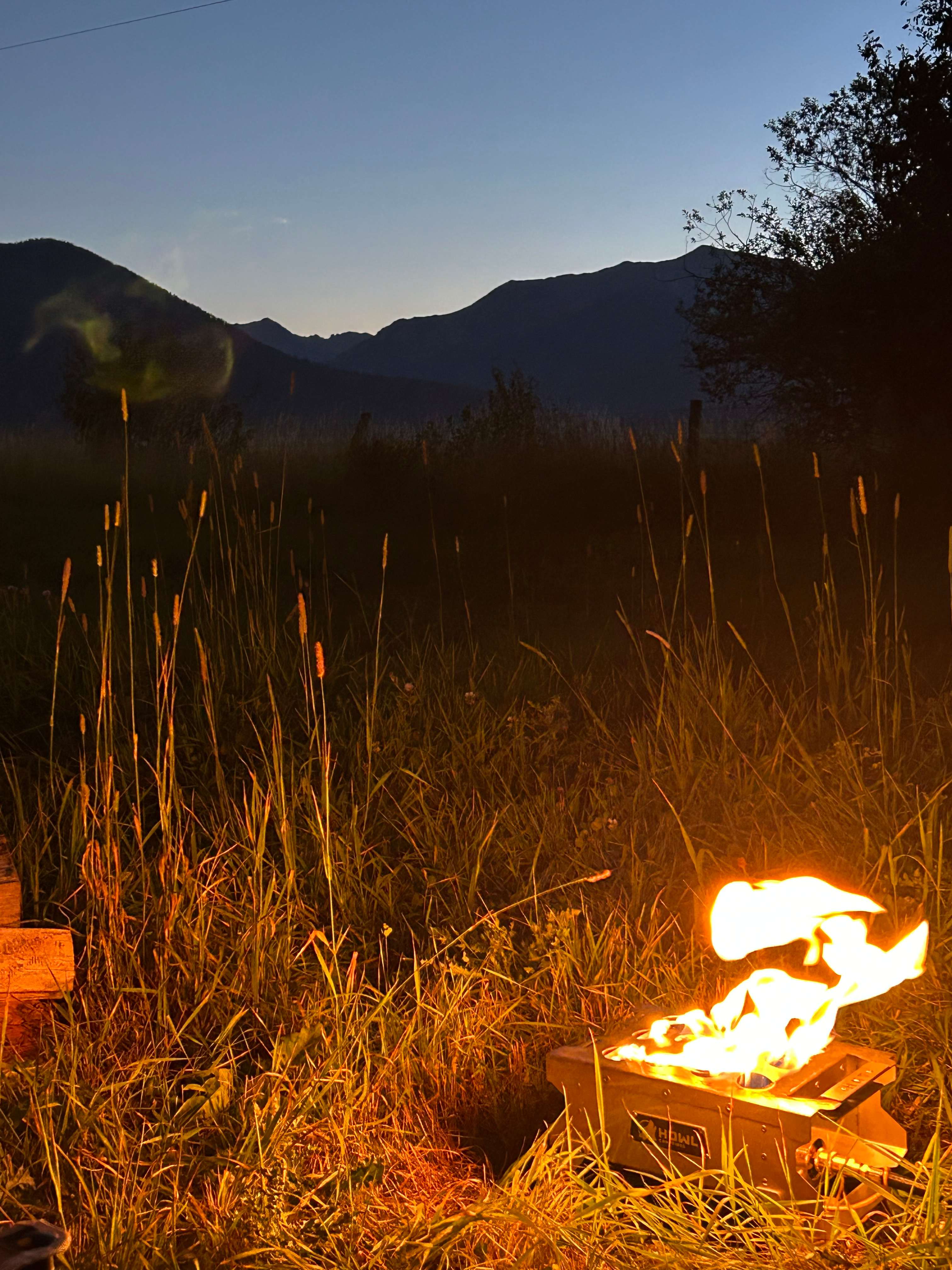 Howl propane fire pit backdropped by the silhouette of the Wallowas. 