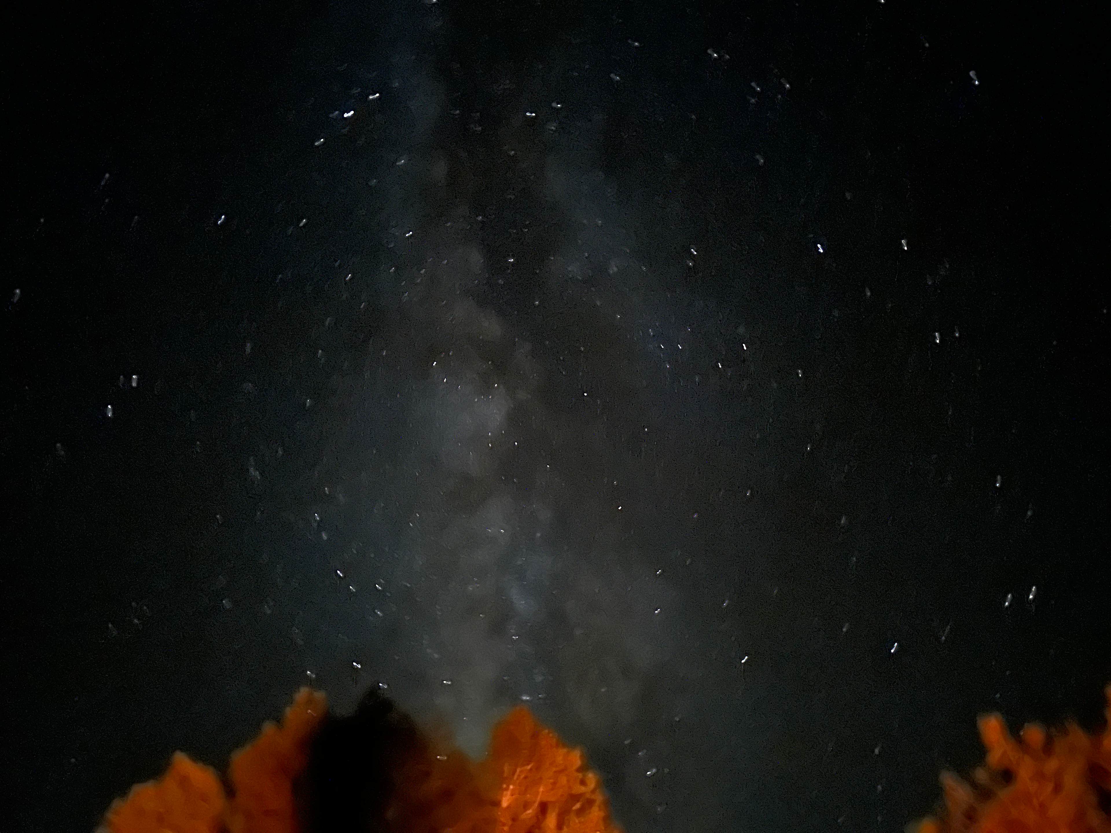 Night sky with the glow of a campfire.