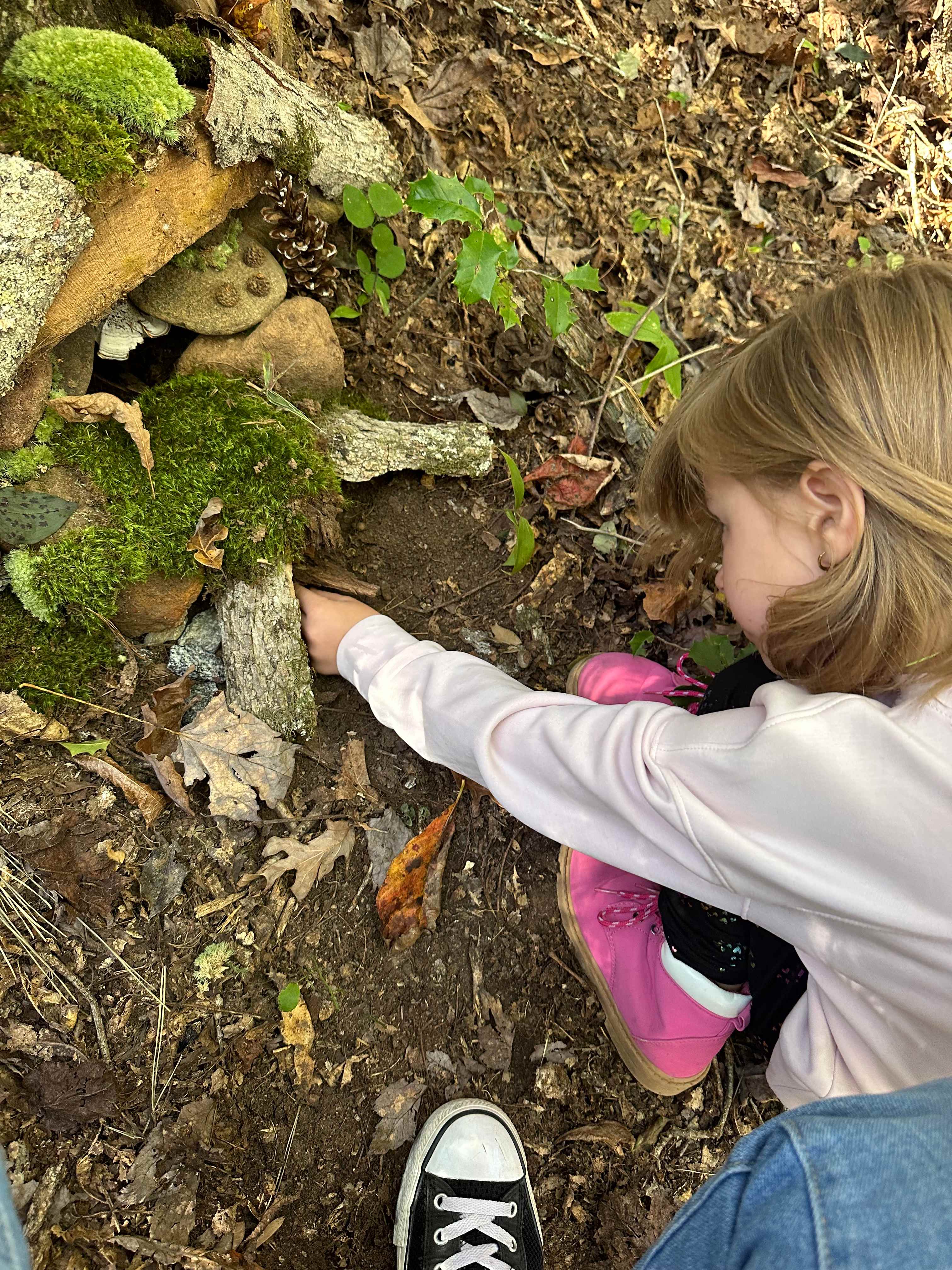 My daughter finishing up the fairy house behind our campsite