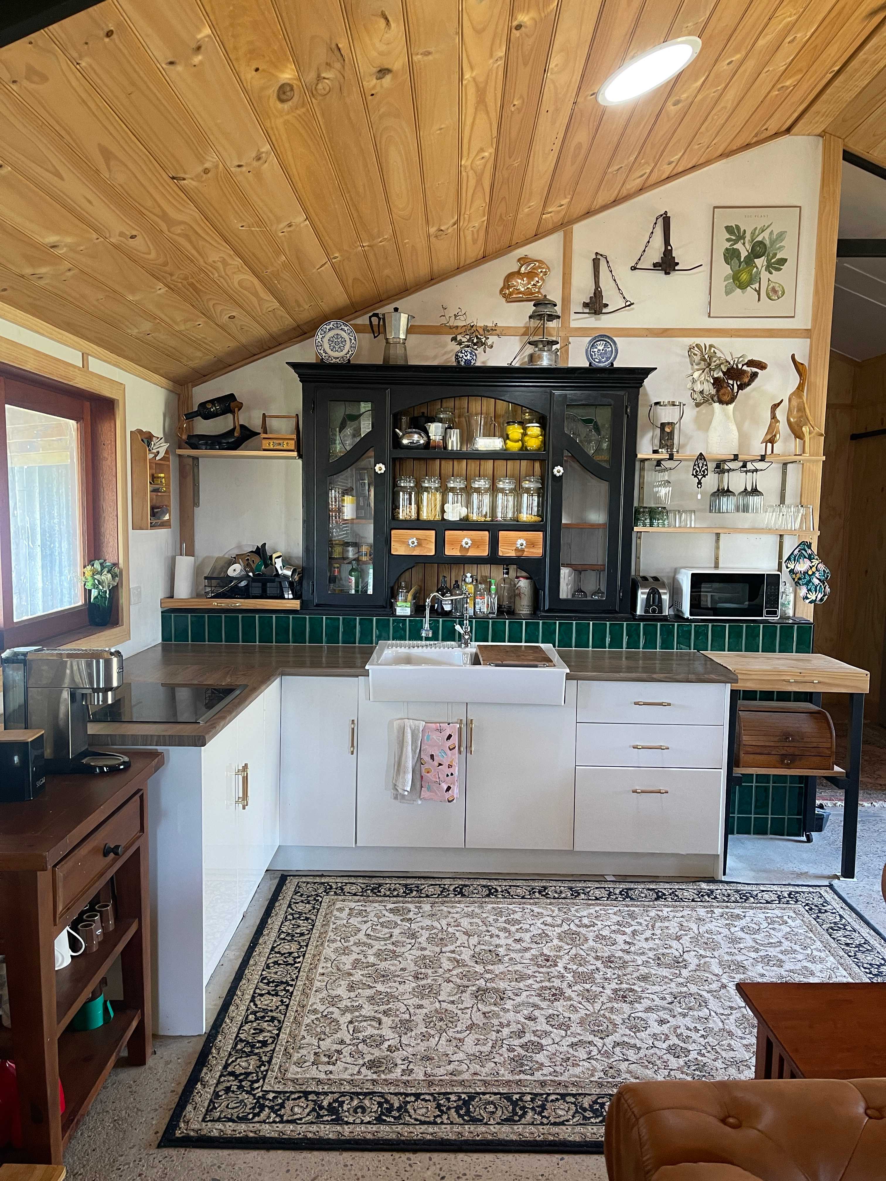 Kitchen, electric stove top and microwave. Fridge in storeroom.