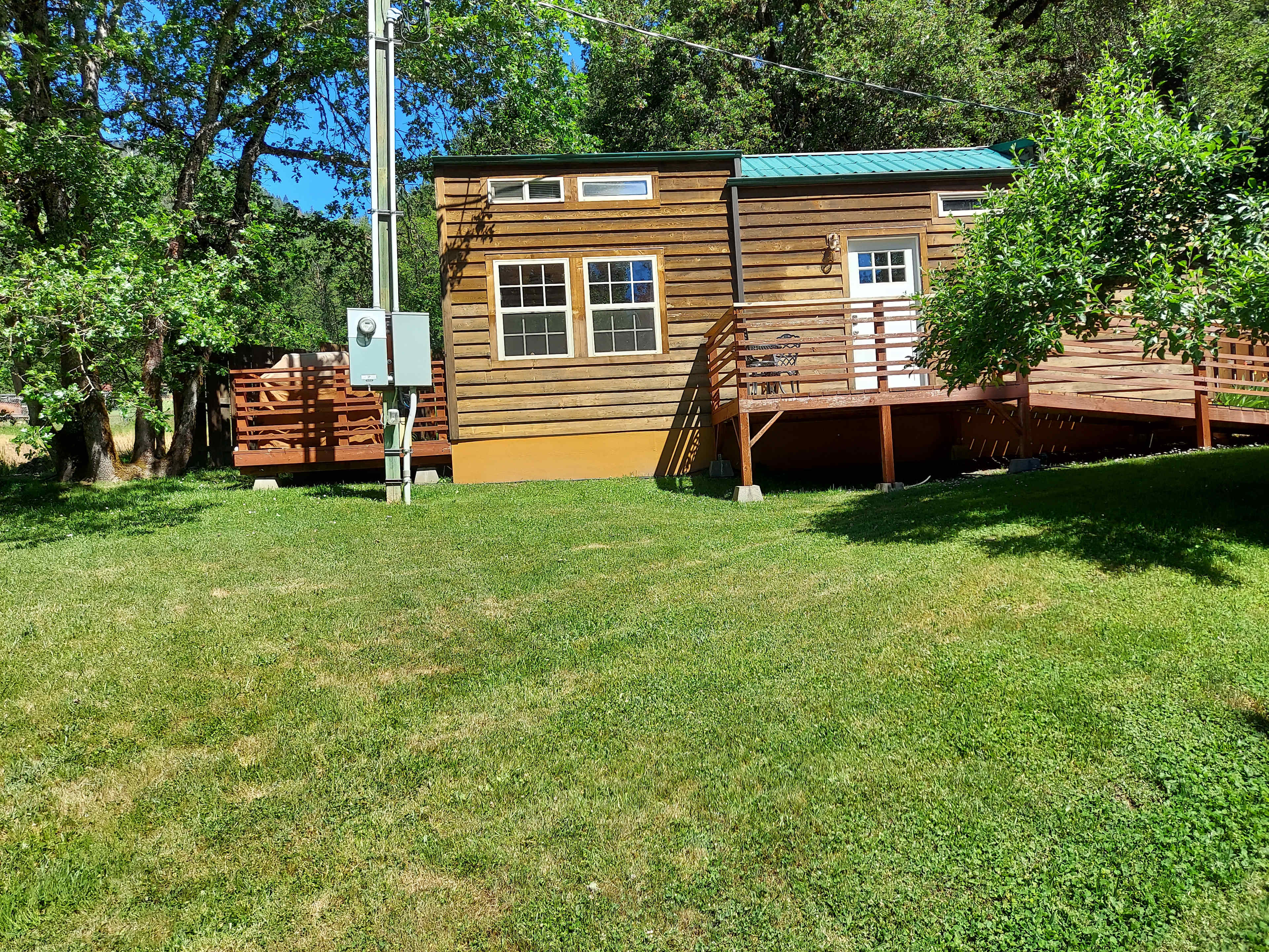 Tiny house with deck, bbq, & patio out back w/fire pit.