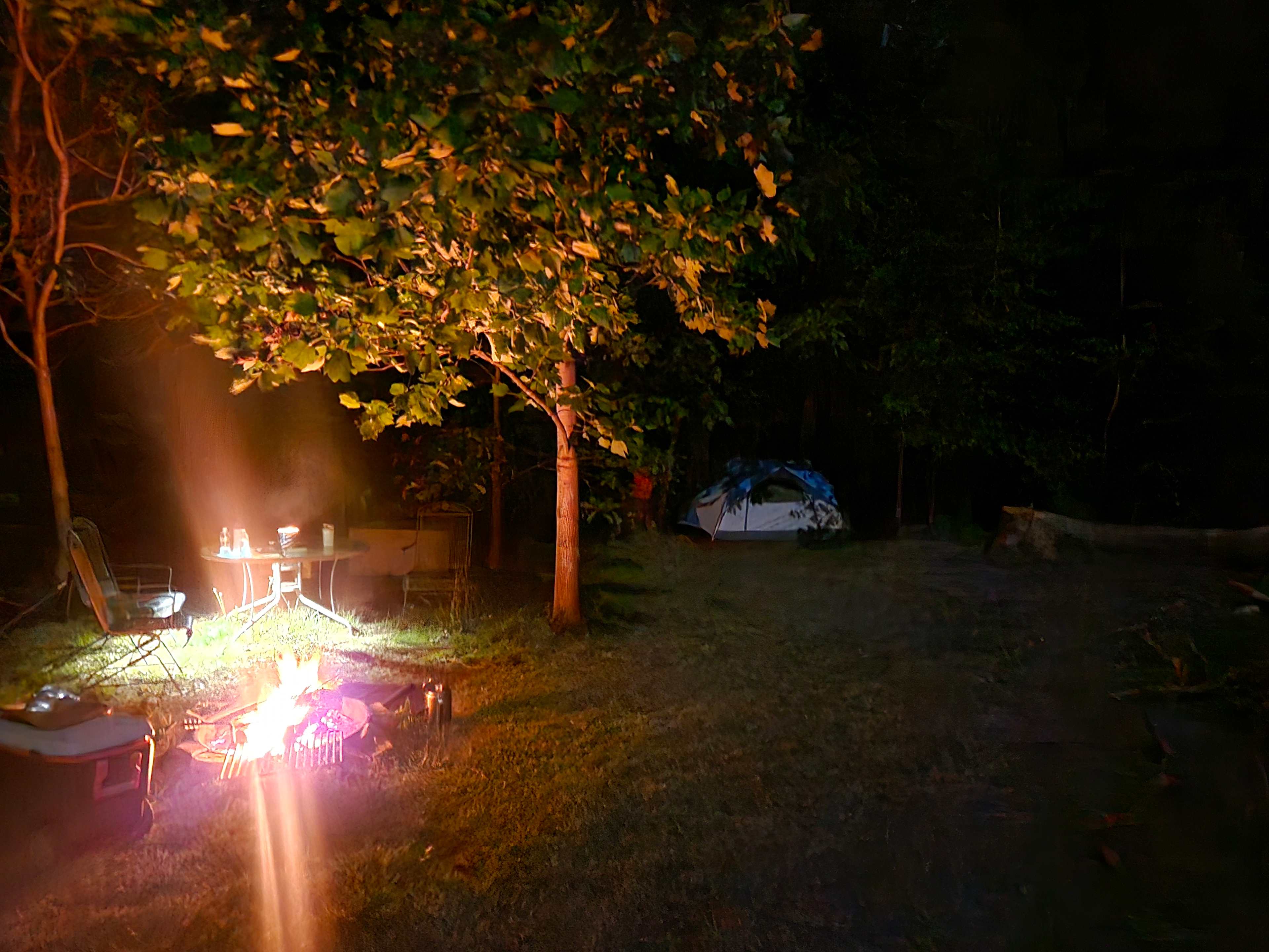Fire pit, table, and chairs to the left of the campsite. Very spacious! 