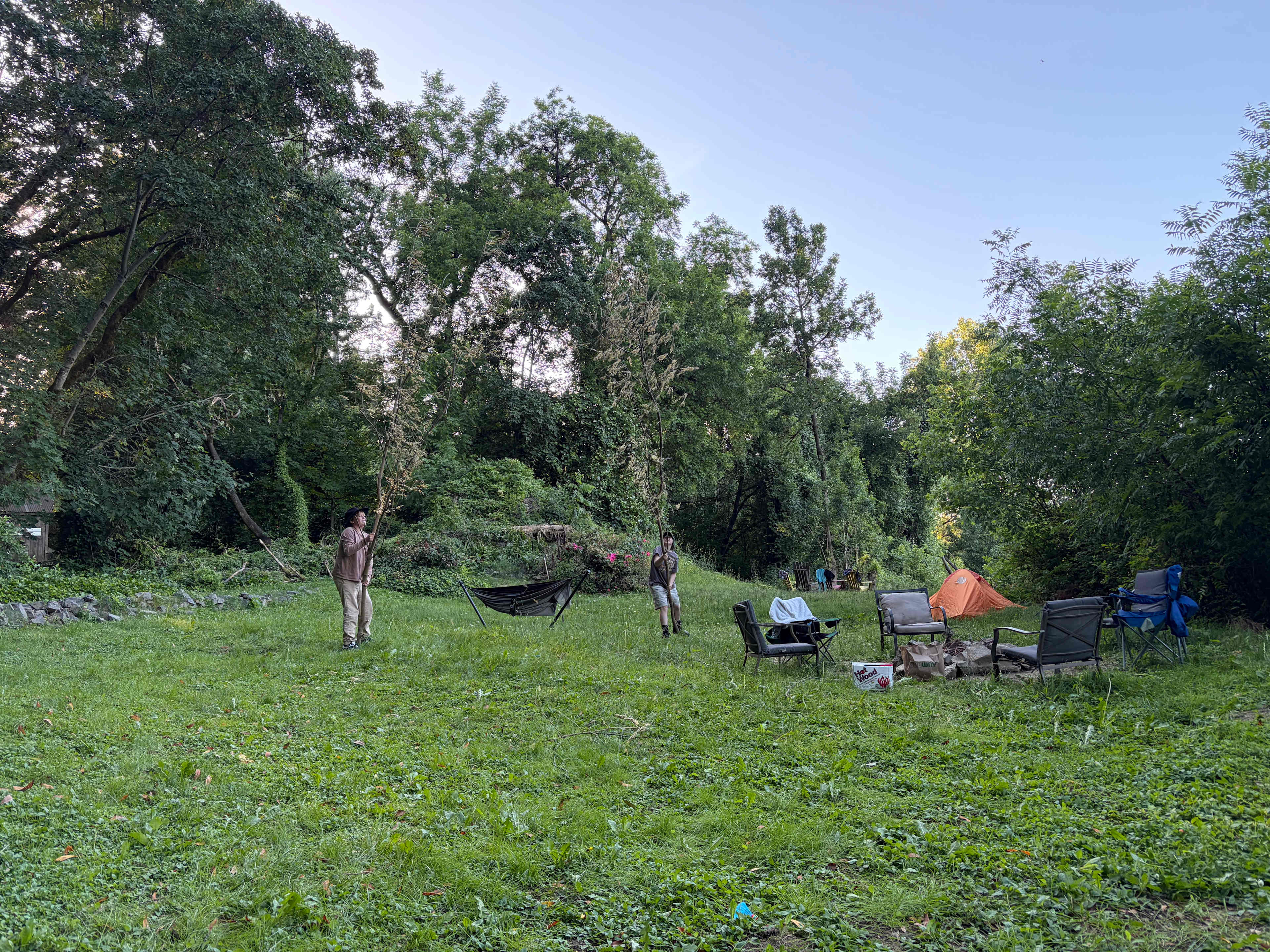 Kids with sticks on the field landing near the BBQ 