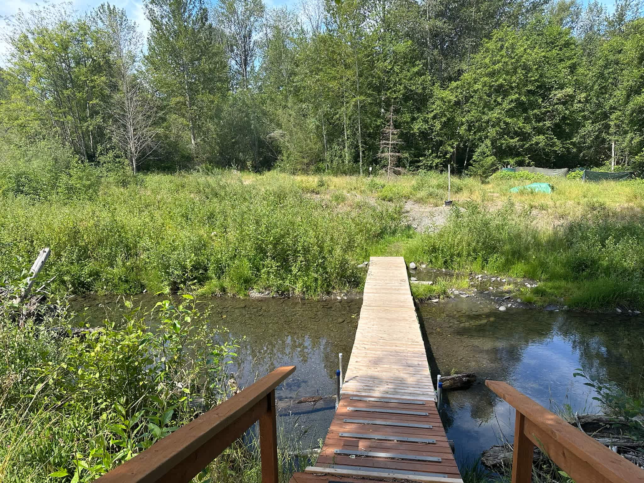 The bridge from the host’s backyard to the island where the campsites are