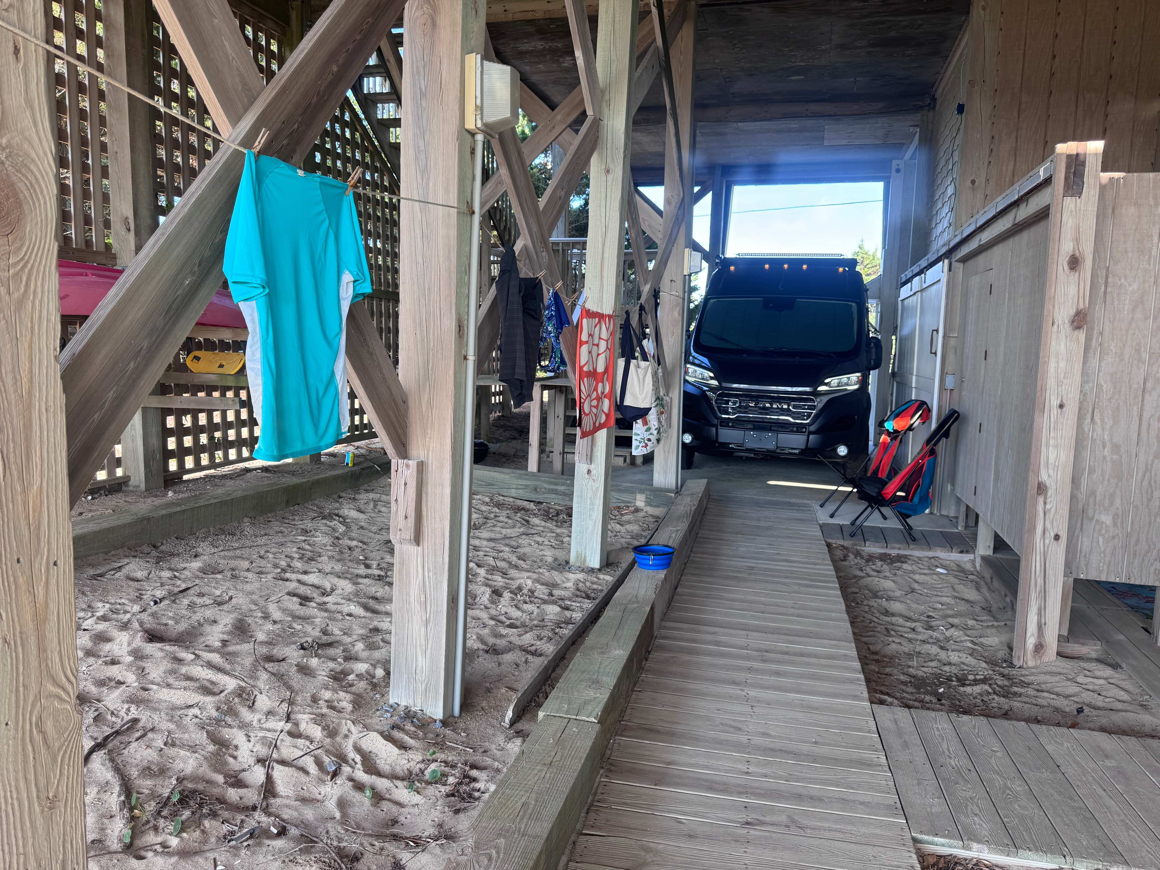Our Promaster in the shade with access to the shower and the toilet.