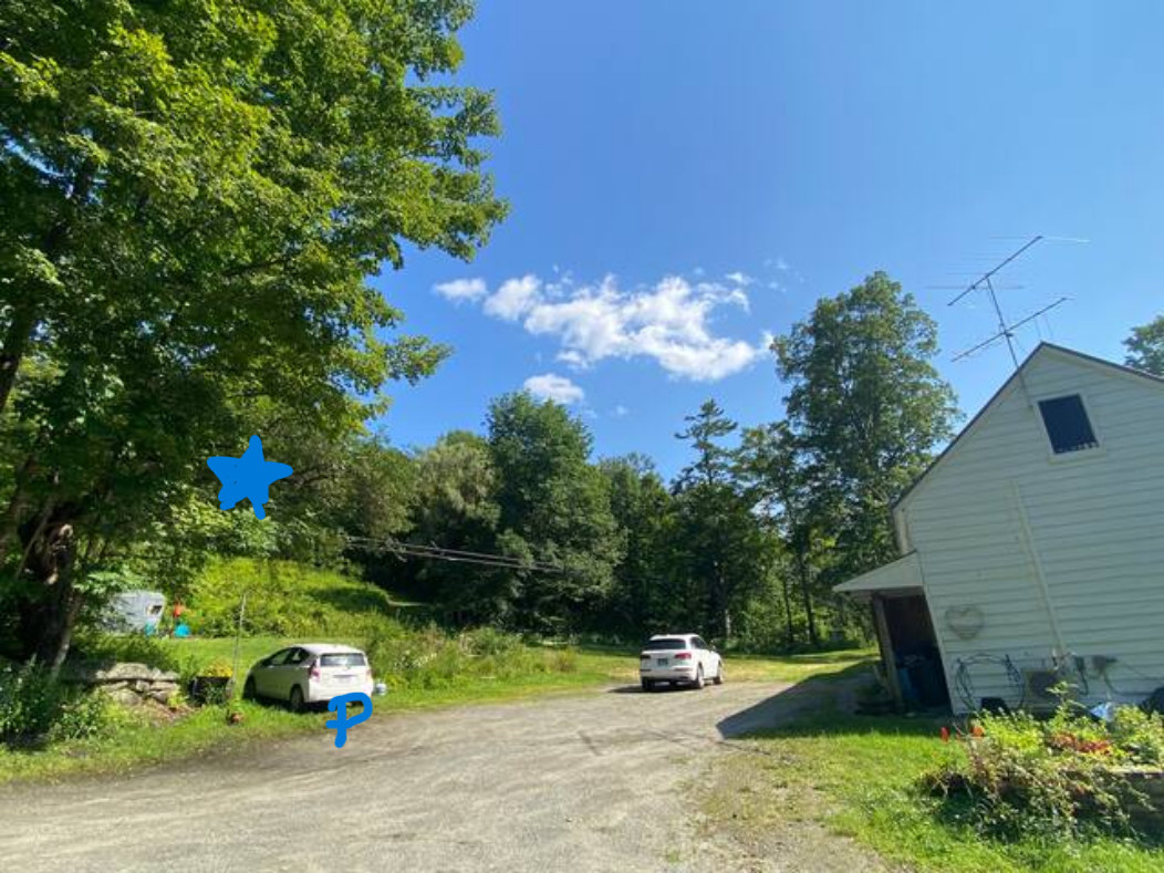 park in farmhouse driveway and walk up the hill to the site