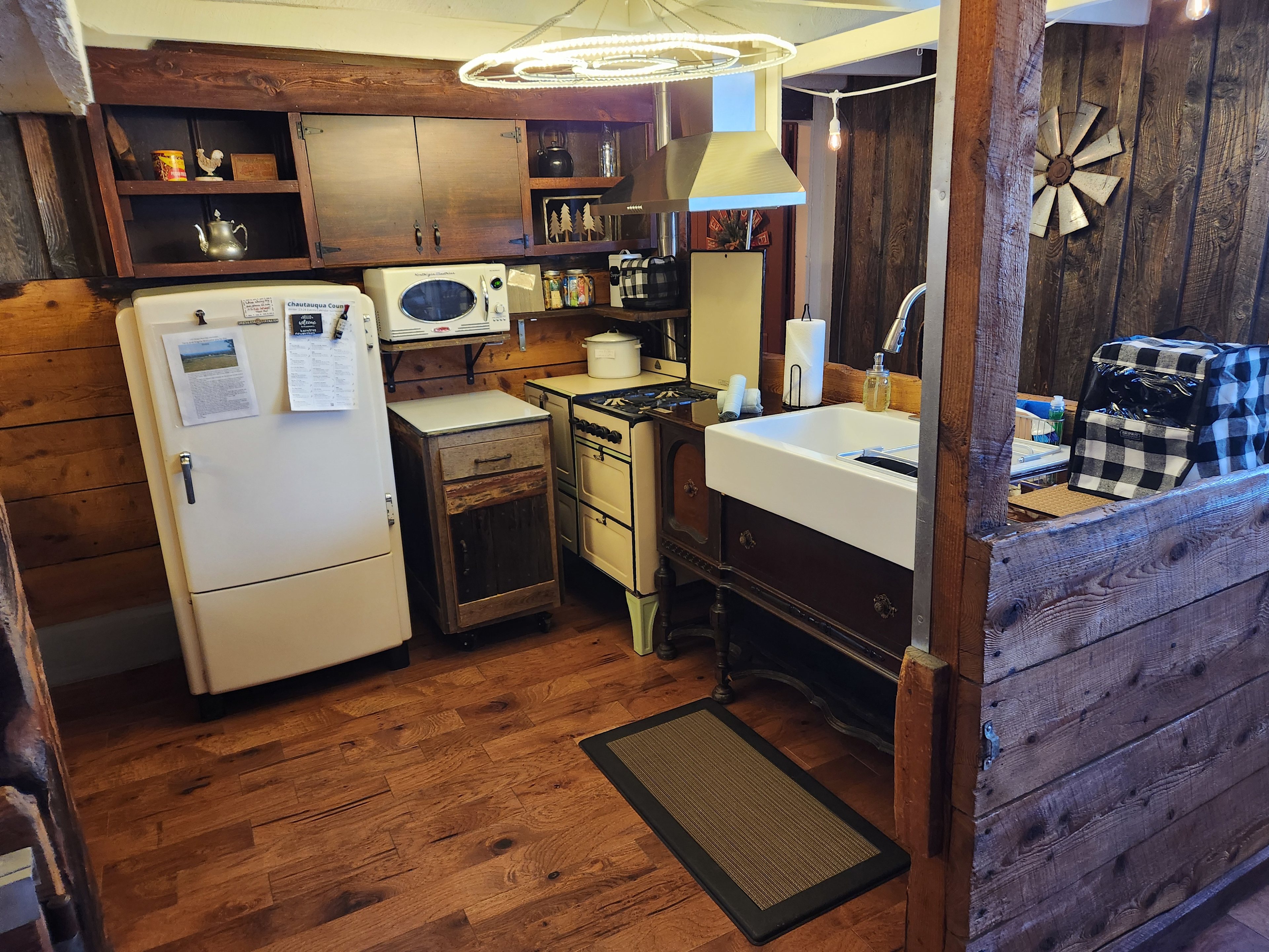 There is a full kitchen, with working vintage 1930's stove and refrigerator. A mobile and lockable center island is stored under the modern microwave. A modern coffee pot and toaster are also supplied.