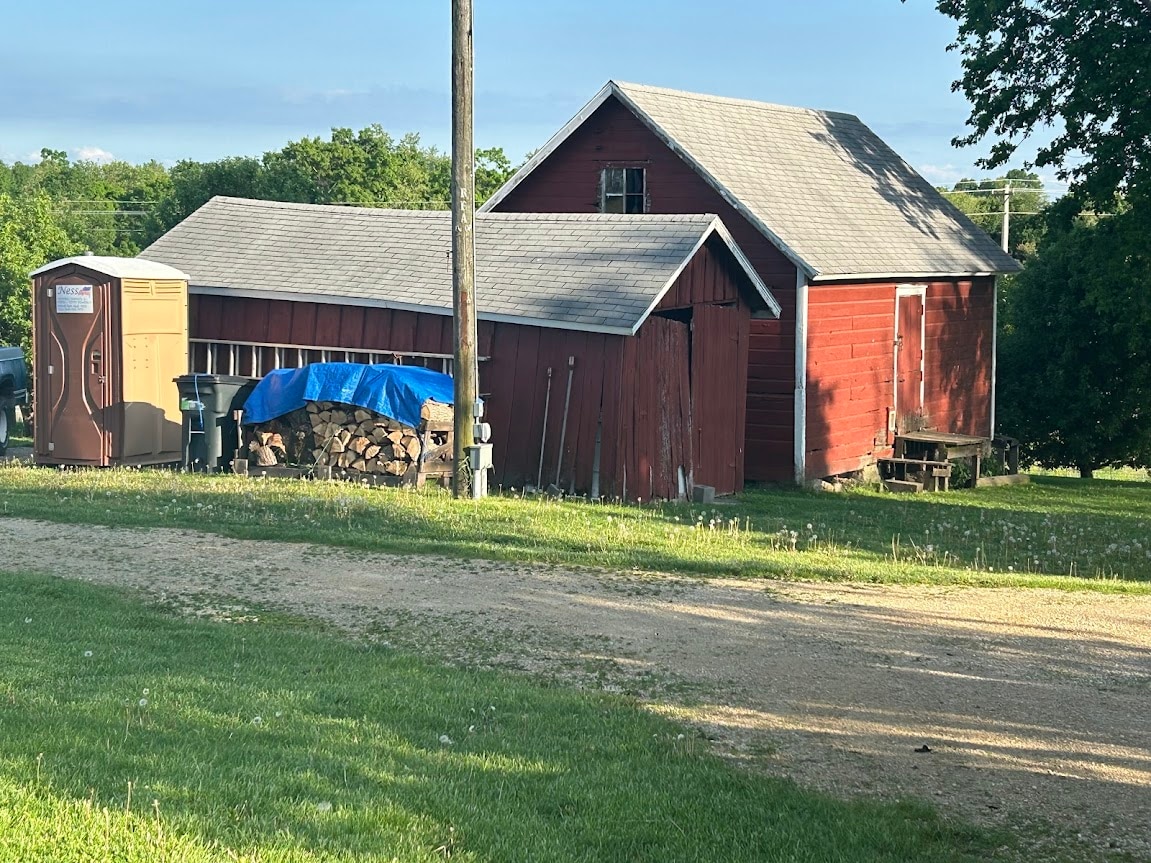 Central parking, near bathroom and wood pile.  Parking on grass in front of the long red "tractor" shed. (the building closest to the light pole, wood and bathroom)
