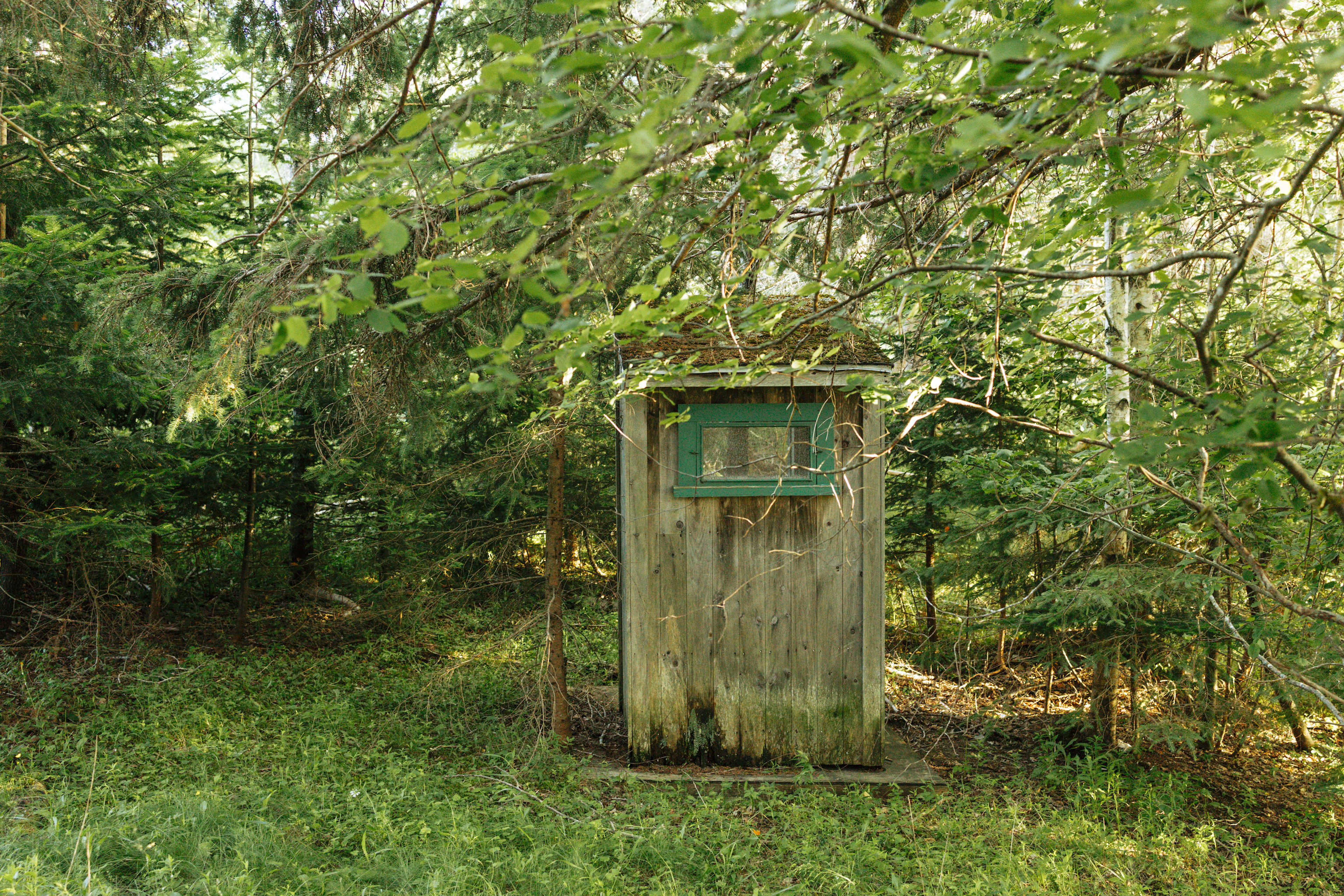 There is an outhouse to the right of the cabin. 
