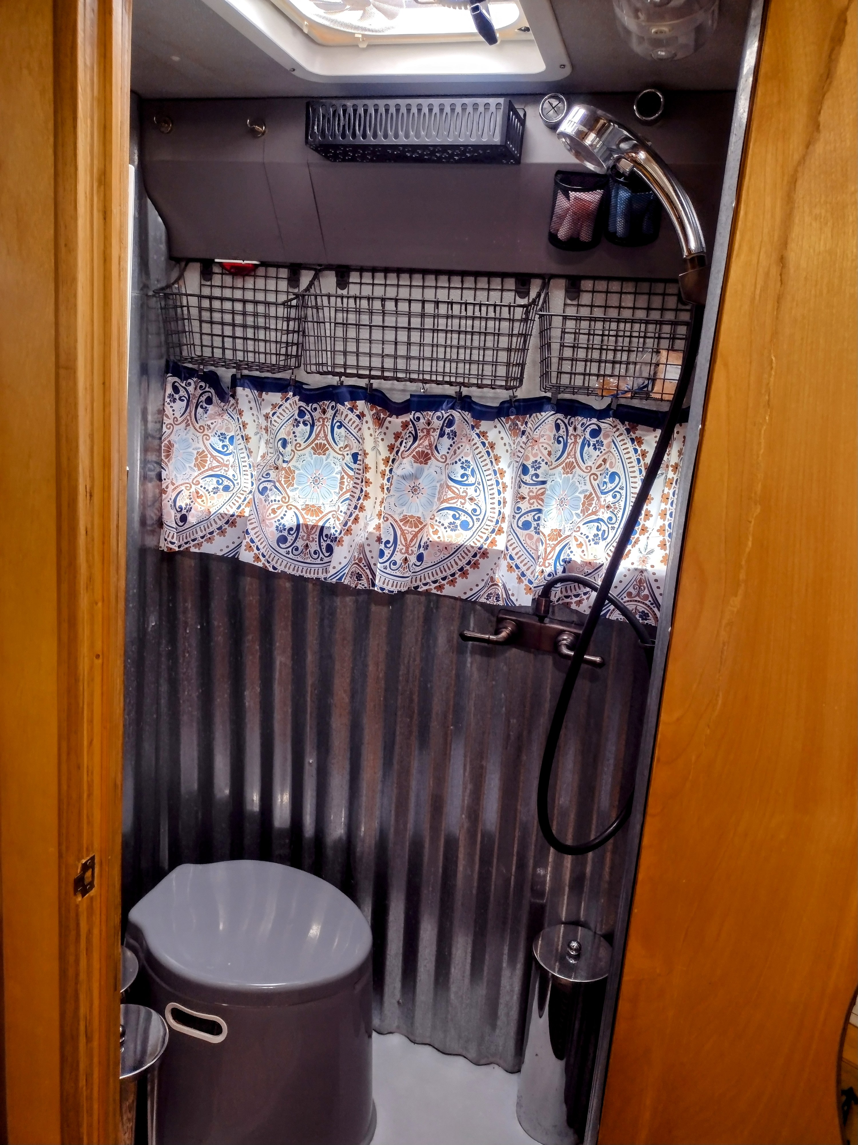 Wet bath with camp bag toilet. Bag toilet supplies (bags, sawdust, toilet paper) are located in the chrome cylinder containers.