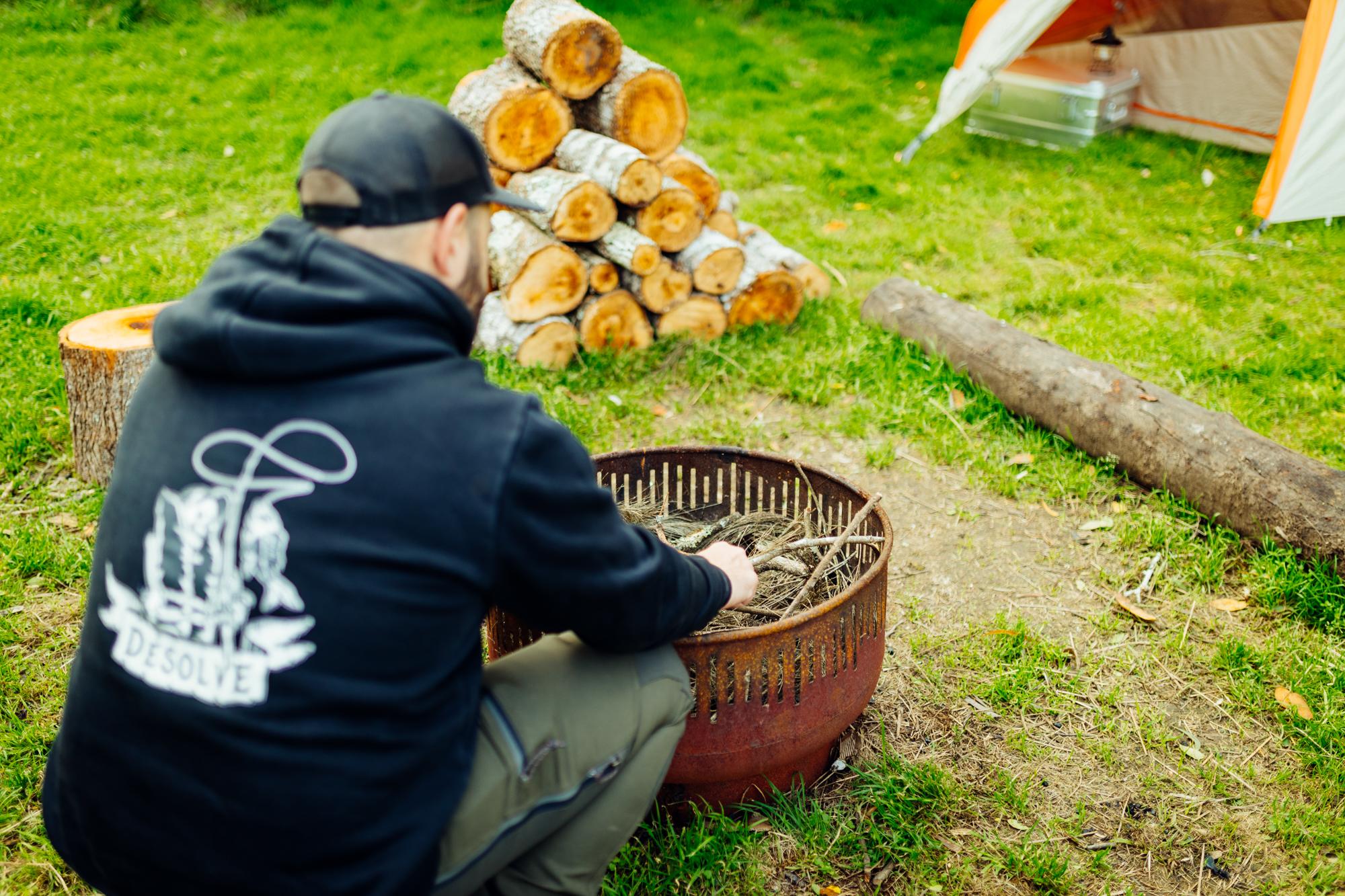 Rearranging dry wood to start the fire
