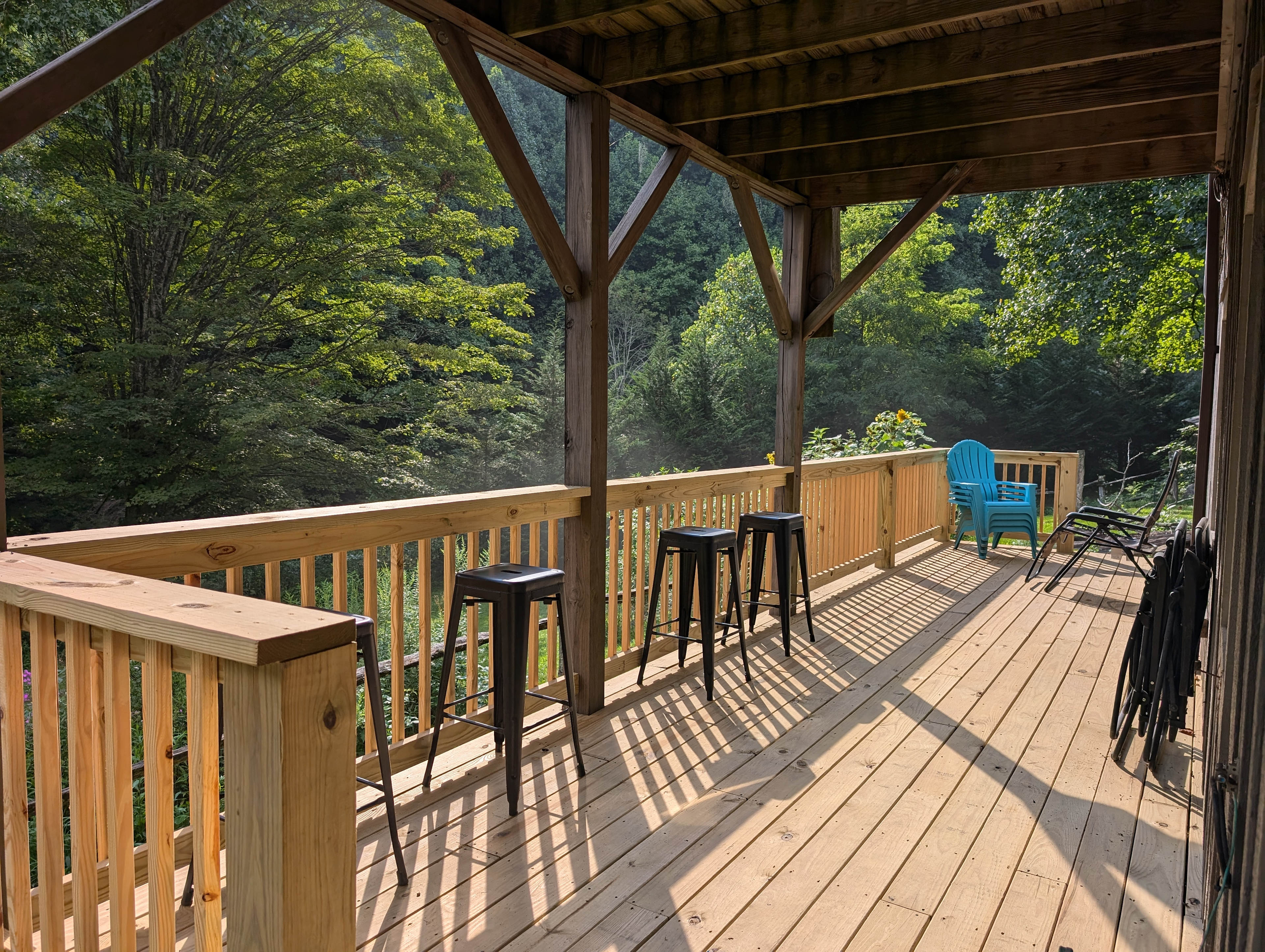 Partially covered deck overlooking flower gardens with lots of birds, butterflies, and bees flying around