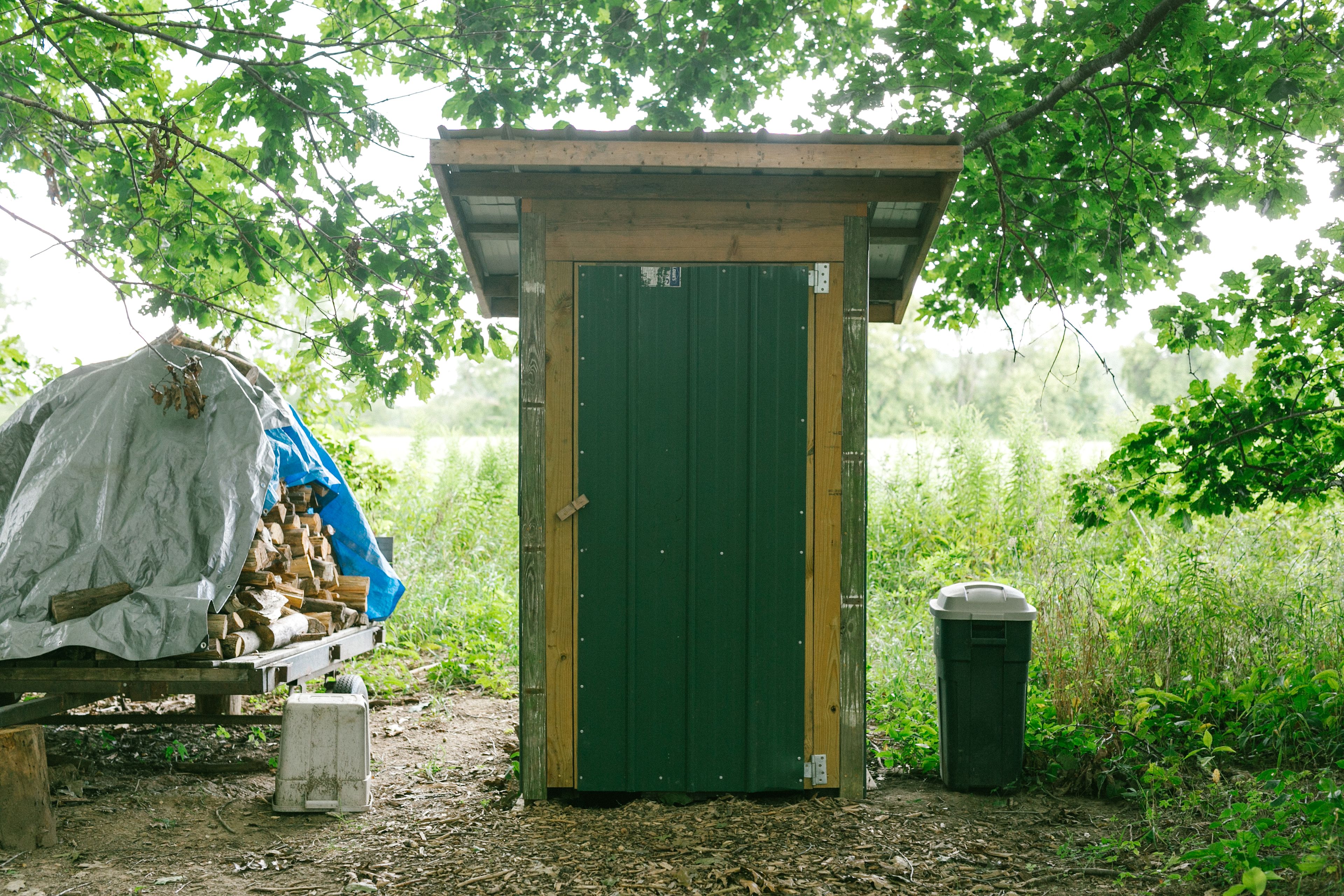The firewood and the outhouse, located near the center of the camping area.