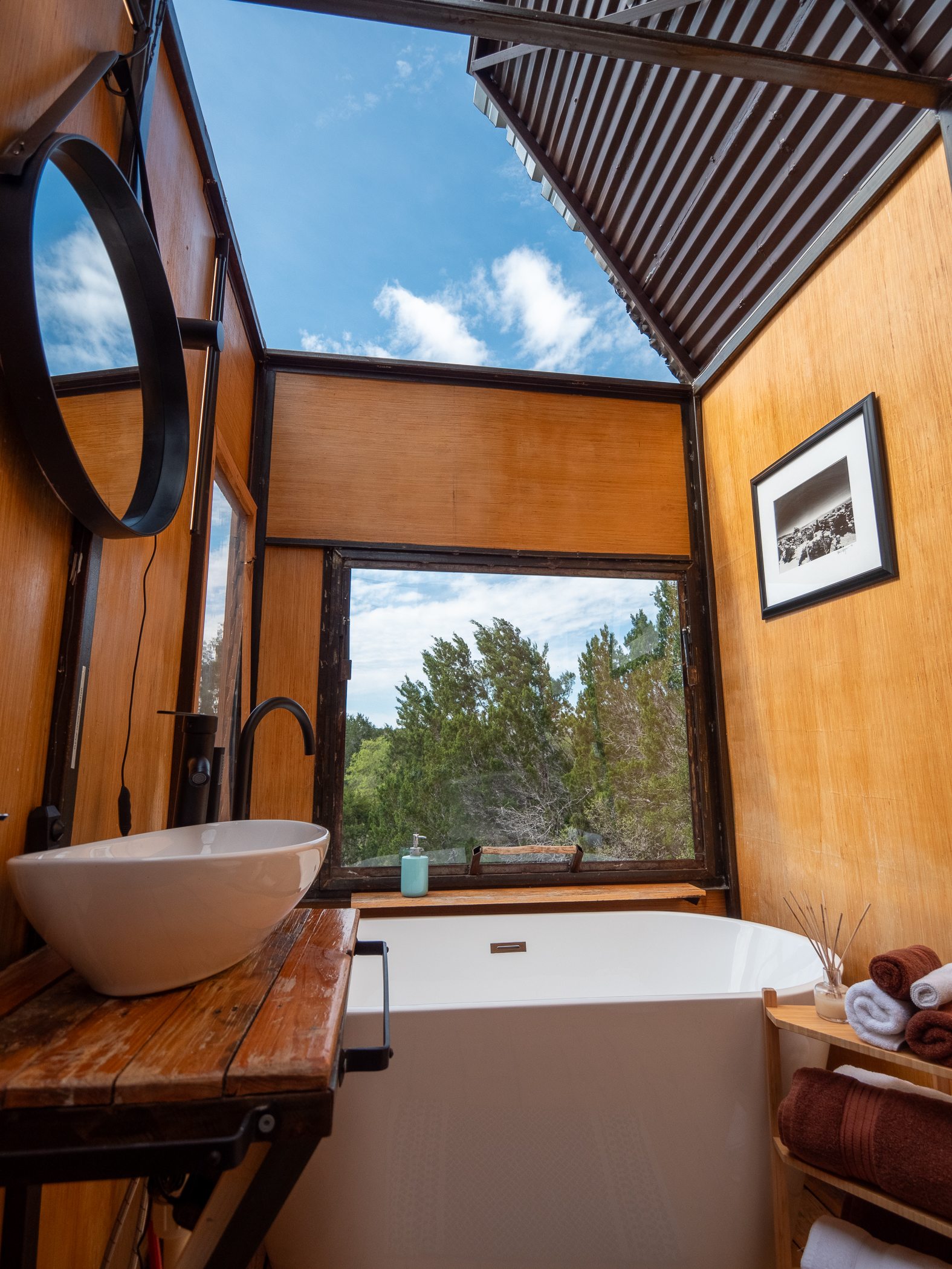 Unwind in an open-air bathroom under the Texas stars ✨ or daylit sky. Enjoy a soak in the tub or a refreshing shower beneath a retractable roof, complete with adjustable lighting to set the mood, plush towels, & purified hot & cold rainwater.