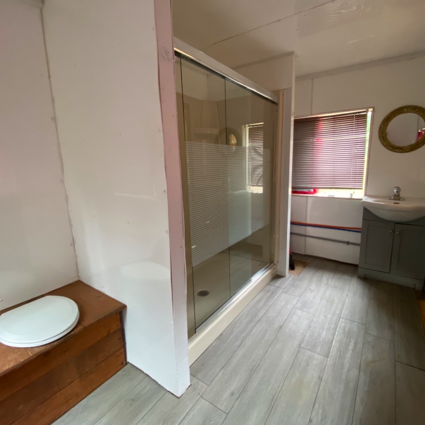 Heated outdoor comfort station with outhouse style toilet, full shower and sink.