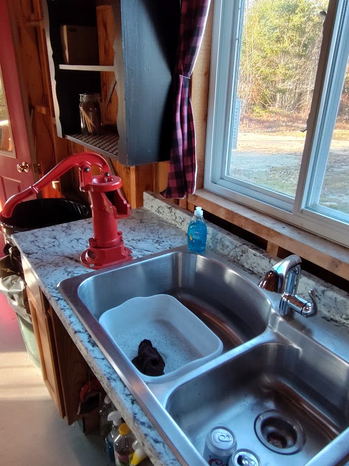 hand pump and 12 volt powered water to faucet from dug well.  (Non Potable water but perfect for dishes and personal hygiene)