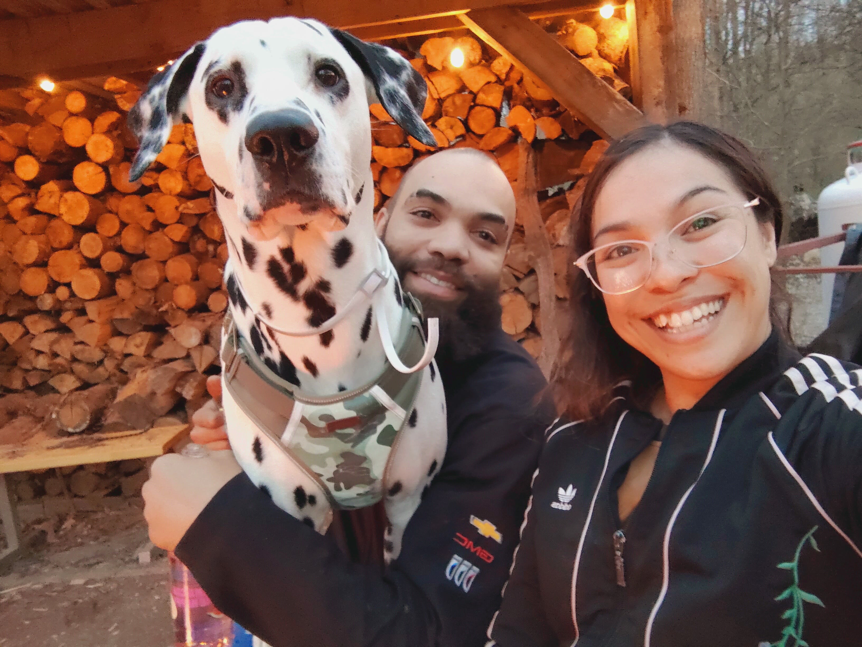Small family of 3 sitting by campfire before sunset 