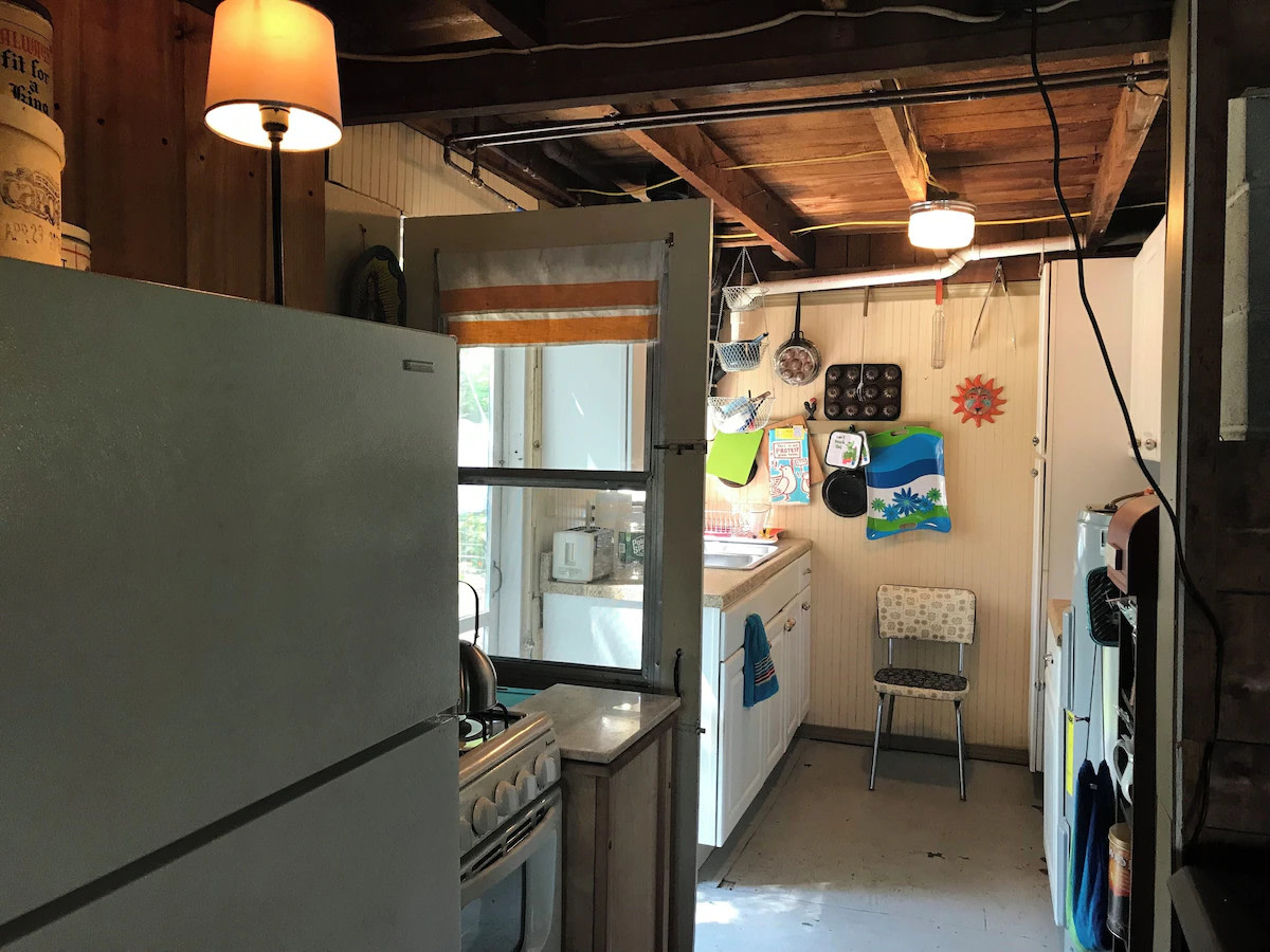 Fully equipped galley kitchen: the appliances include a propane gas range, full-size fridge with freezer compartment, large microwave and large toaster oven, coffee maker and tea kettle. The kitchen door goes out to a small deck with clothesline.