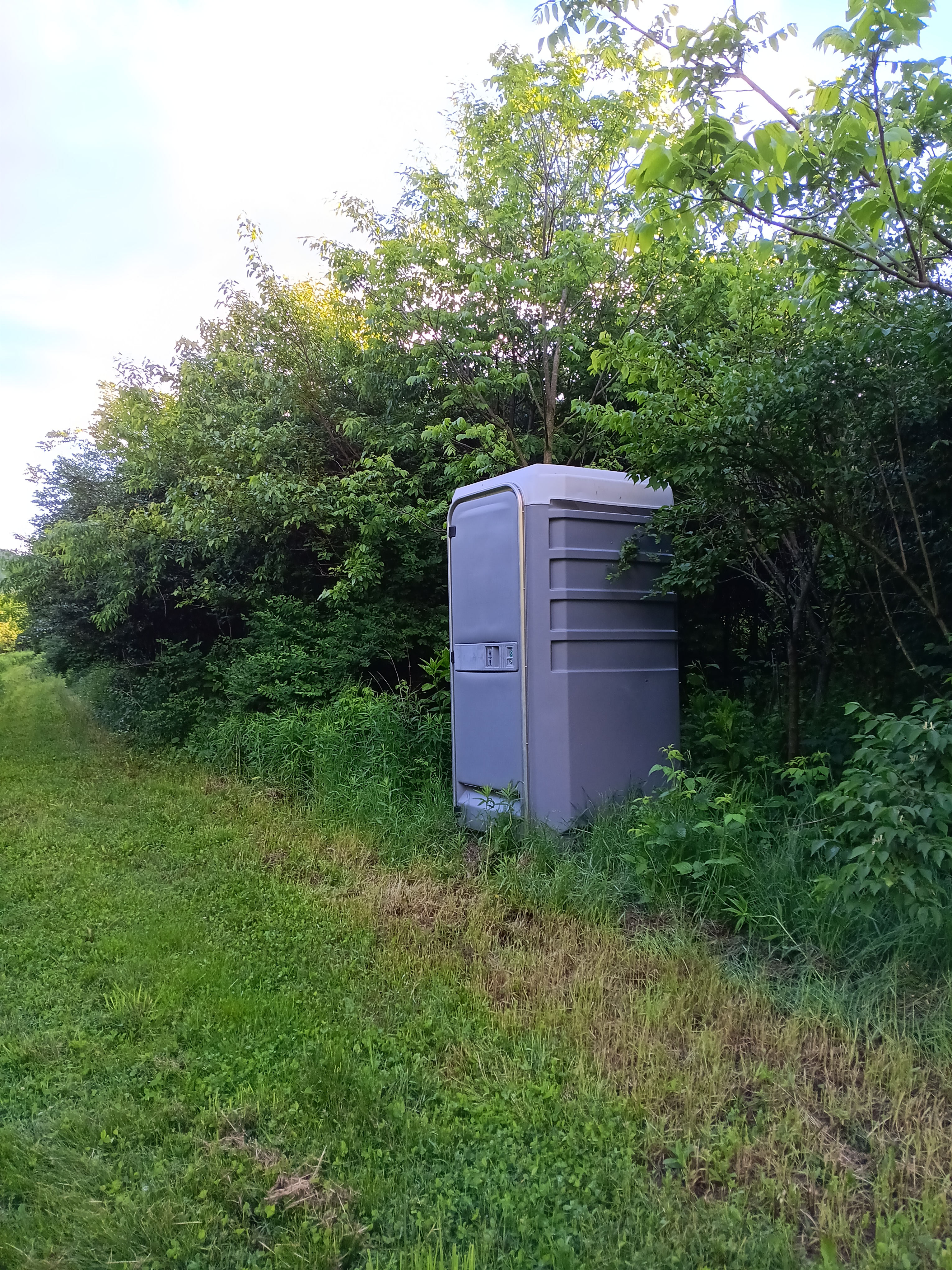 Portable toilet on trail with hand washing station. 