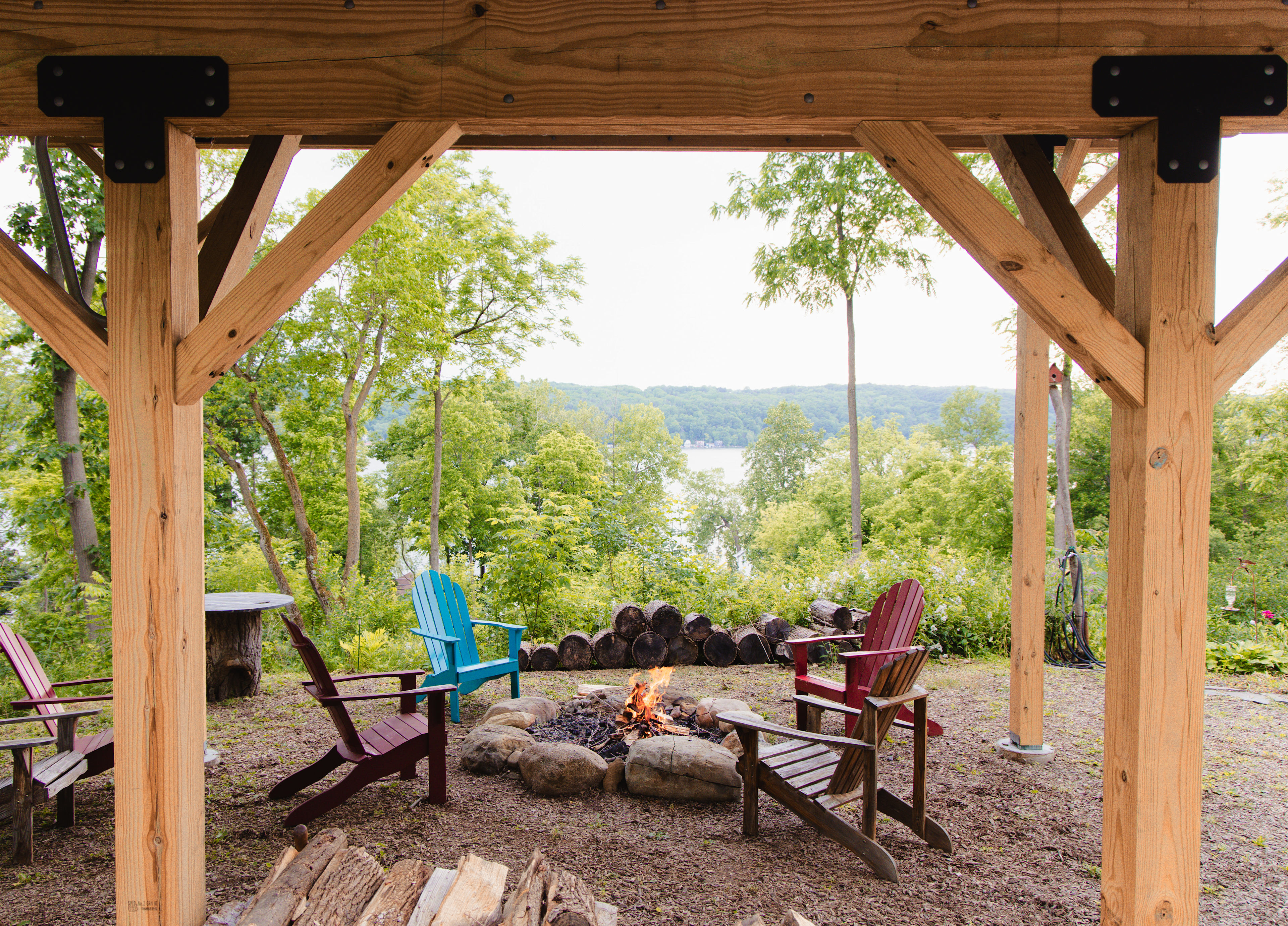 Firepit under the pergola with stocked firewood and beautiful views of the lake. 