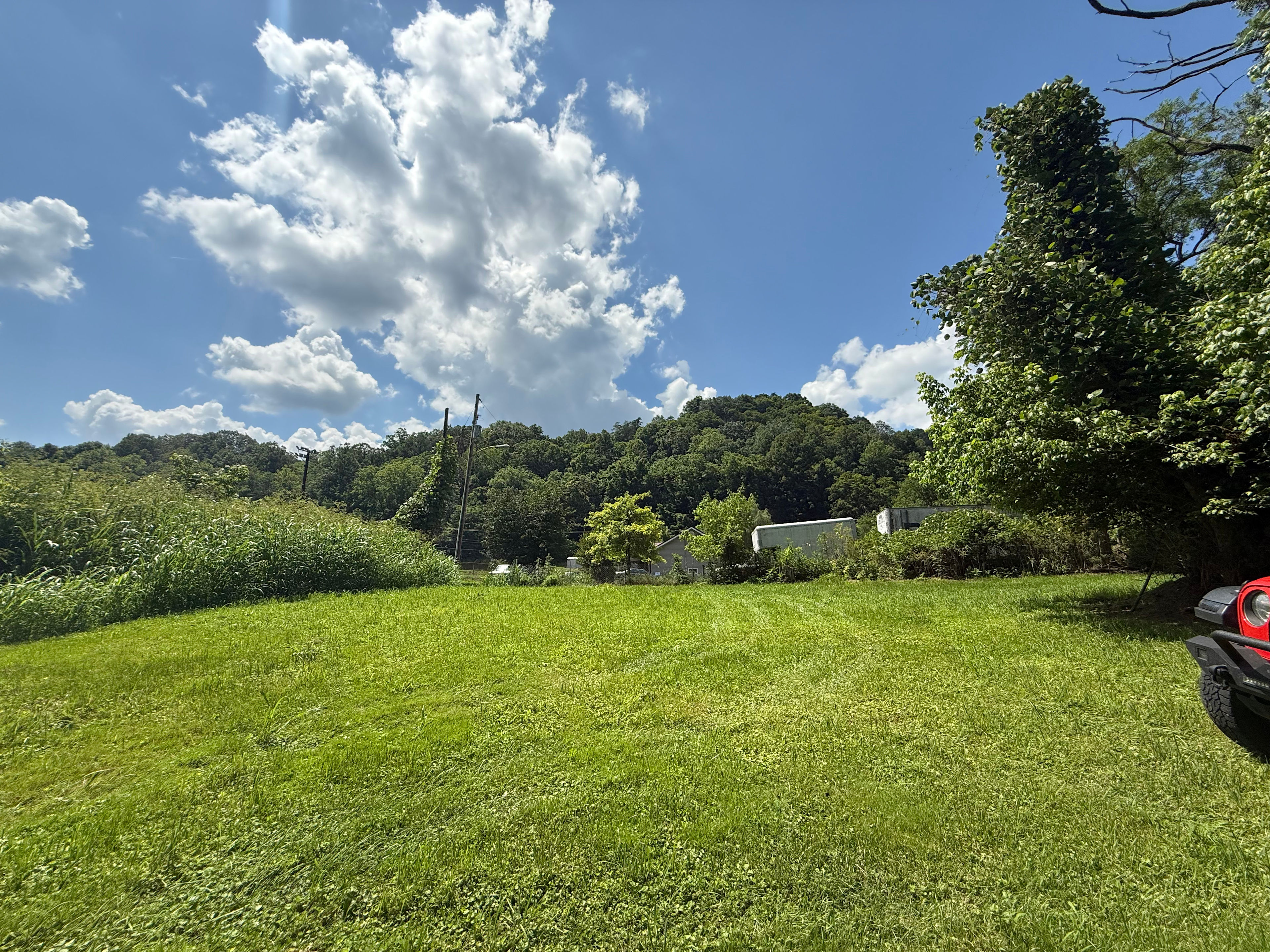 View from river looking to back of property to show neighboring property. There is a small natural barrier as well as storage shed/outbuildings between properties.