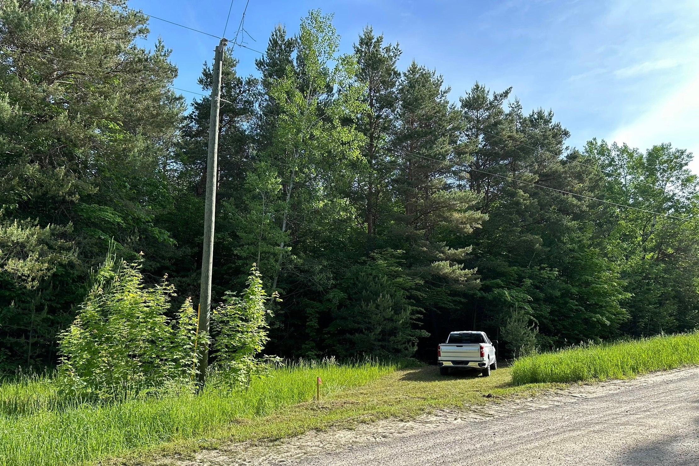 Photo from the road. I’ve since added a post with an address sign that is visible from the road. My property is off a dirt road. However the roads leading to it are paved. If you come from the east it is 0.7 miles of dirt road or 0.3 miles from the west. 