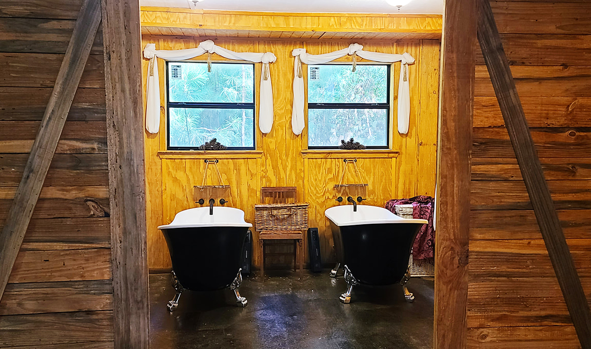 Rustic Trails Texas LLC two clawfoot bathtubs with sliding barn doors for privacy.