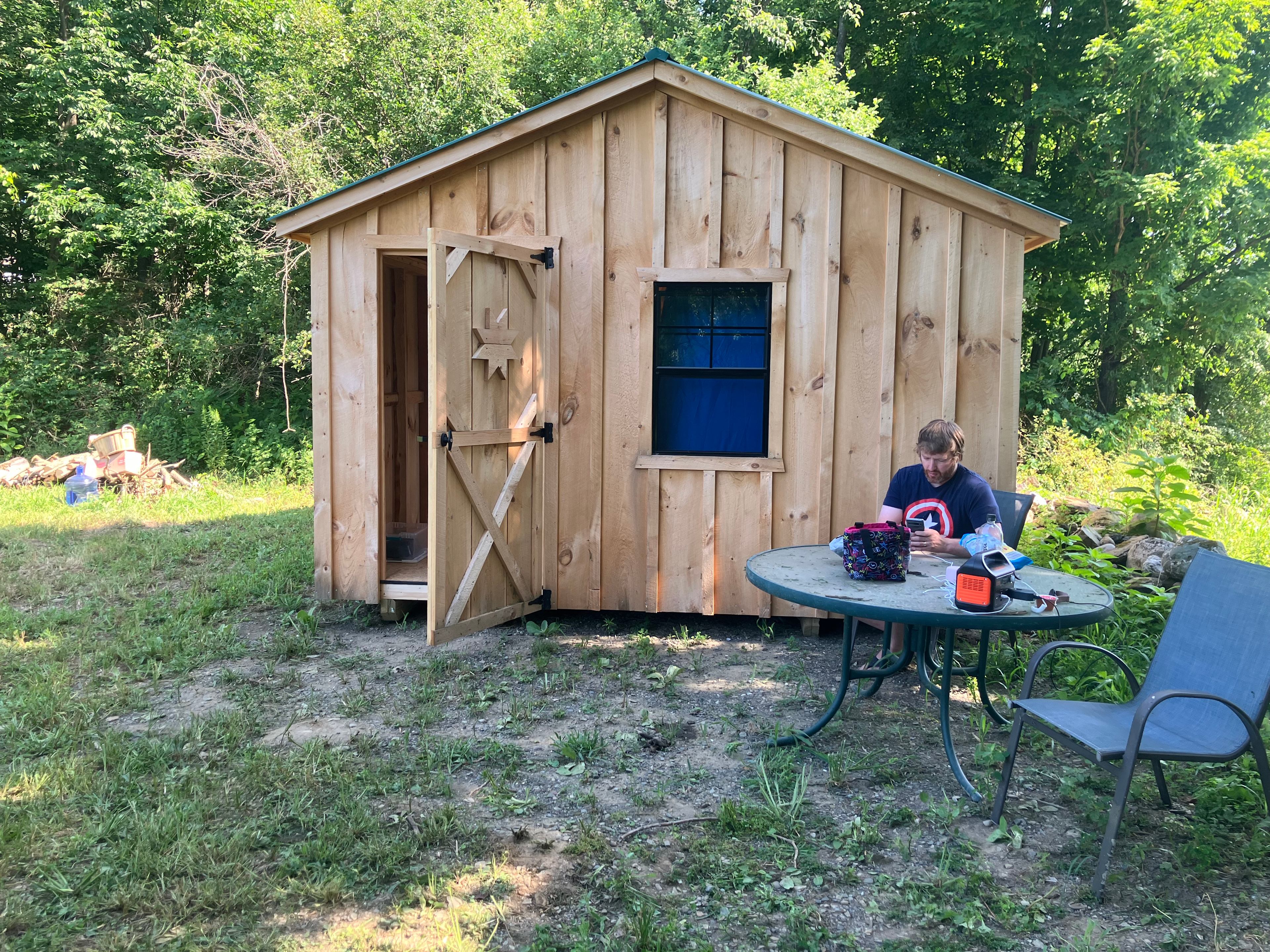 Fire pit to left with supplies. Cabin larger than picture appears. Table and chairs provided. We brought Jackery for power needs, no power on site.  