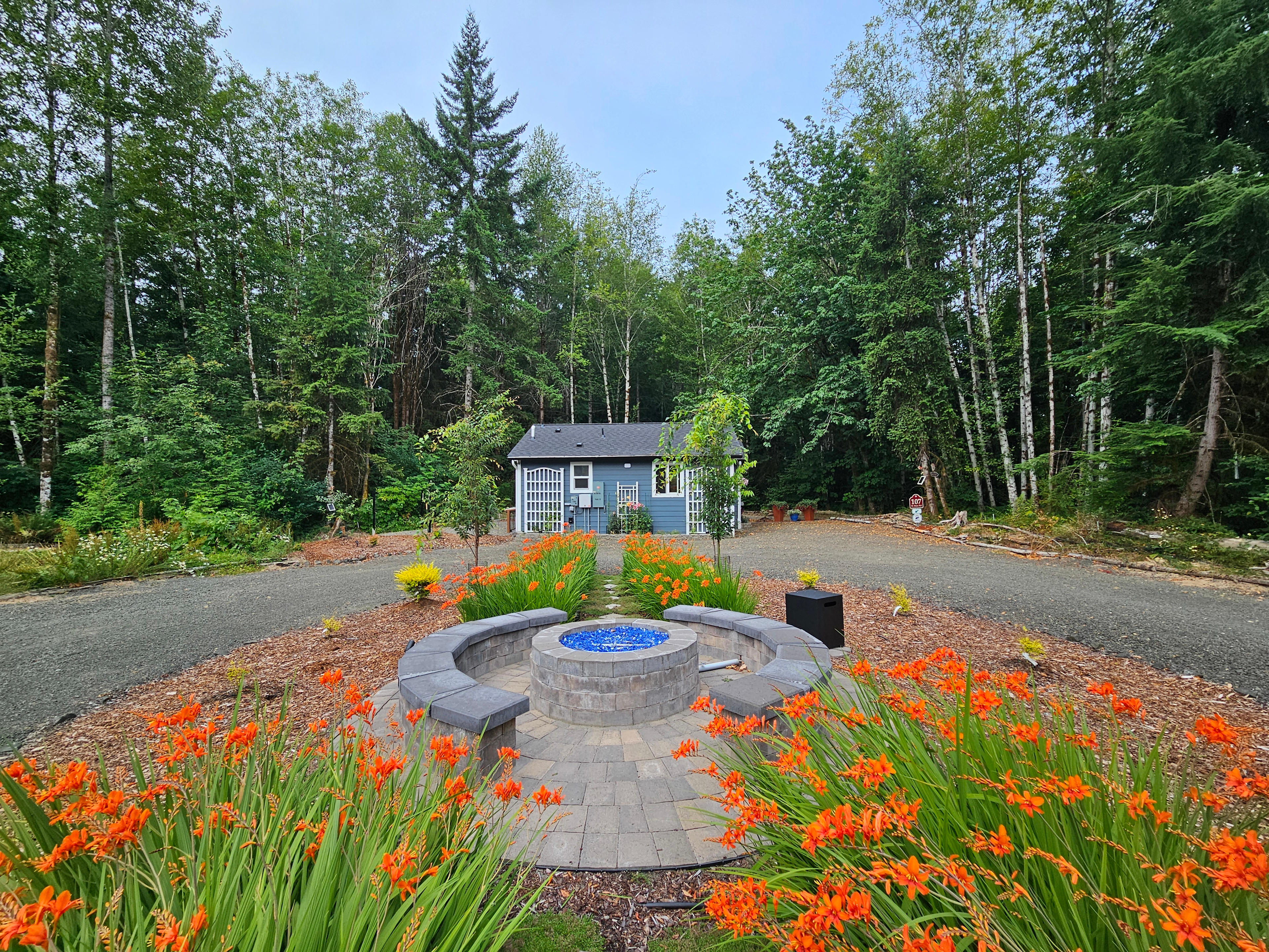Propane fire pit and seating area between the 105-RV Site and 107-Cottage