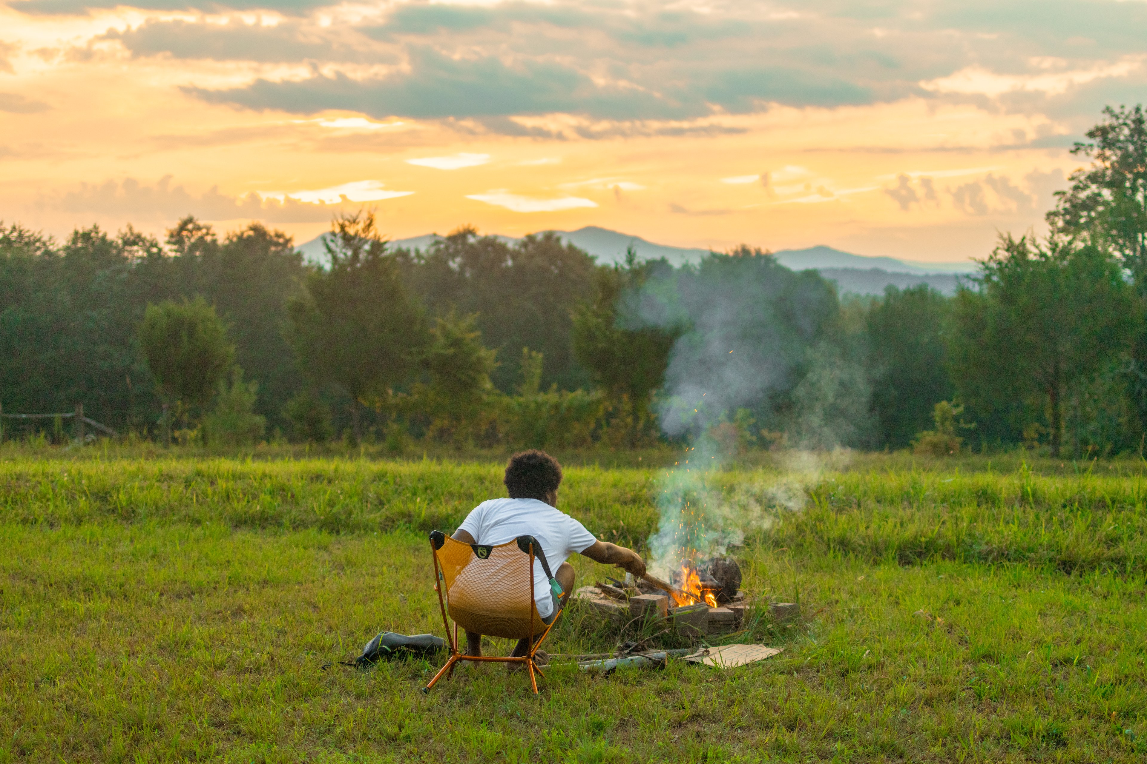 Tending to the fire while the sun sets