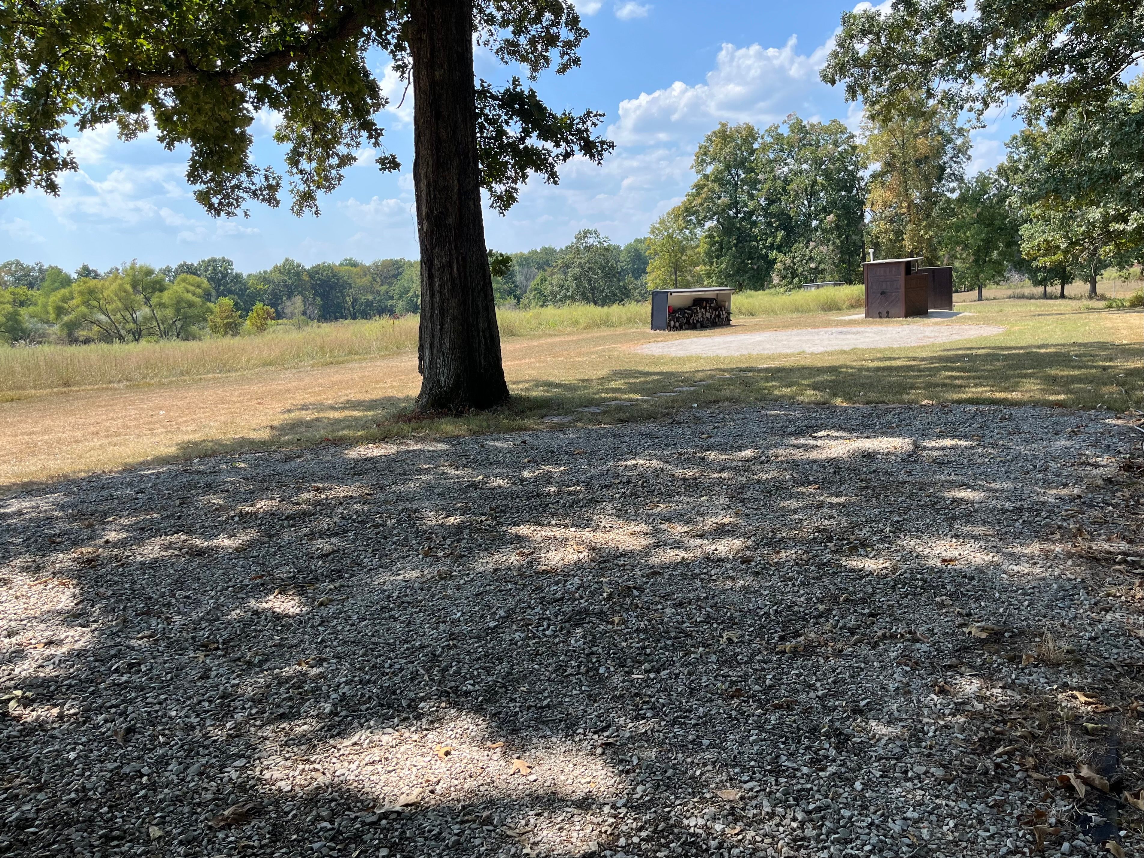 Fireside camping pad is close to outhouse, fire pit and fire wood storage. 