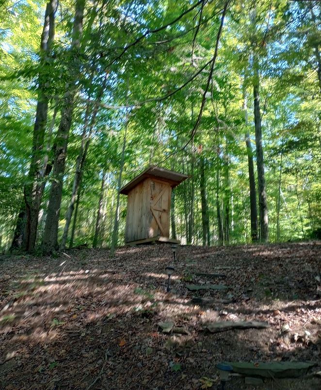 newer looking outhouse.  Clean and well stocked.
