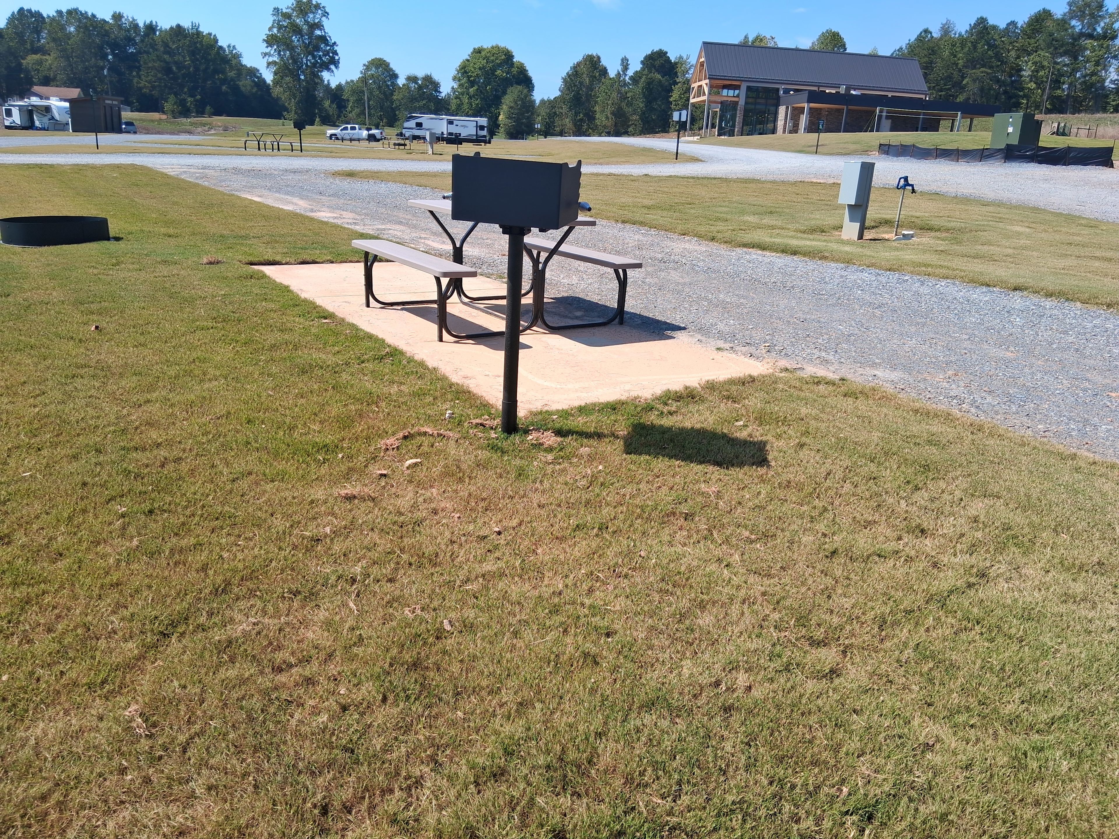 One of spacious sites.  All sites have 50 amp electric, water, (sewer on most) Wi-Fi, charcoal grill and fire pit. Our Clubhouse is in the distance.