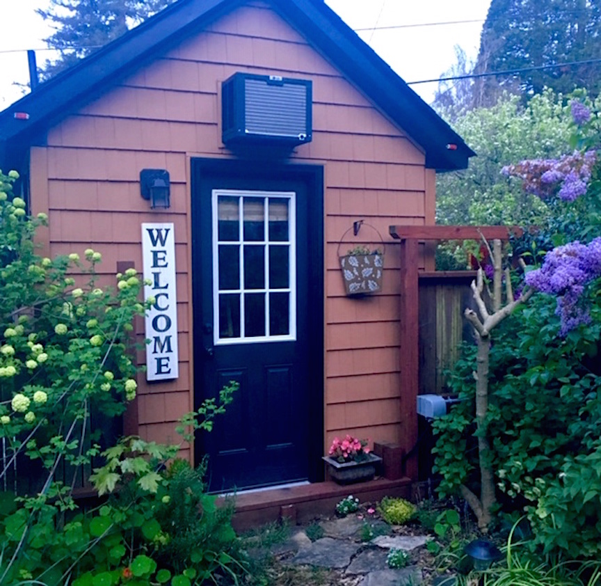 C’mon in and live large in Jenny, my cozy tiny house RV in a lush garden