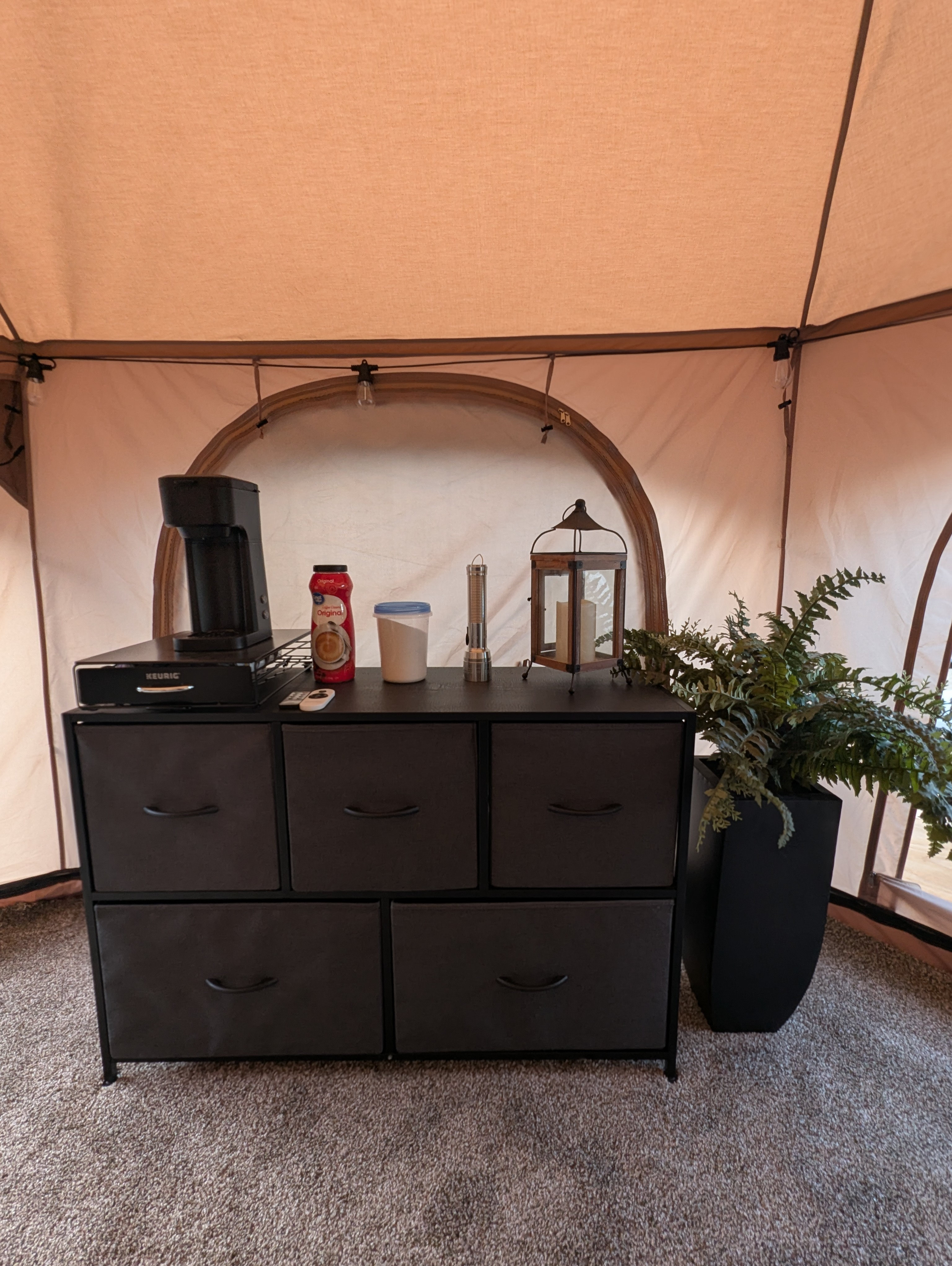Dresser with Keurig style coffee maker. Creamer, sugar, different varieties of coffee. Flashlight for nighttime. 