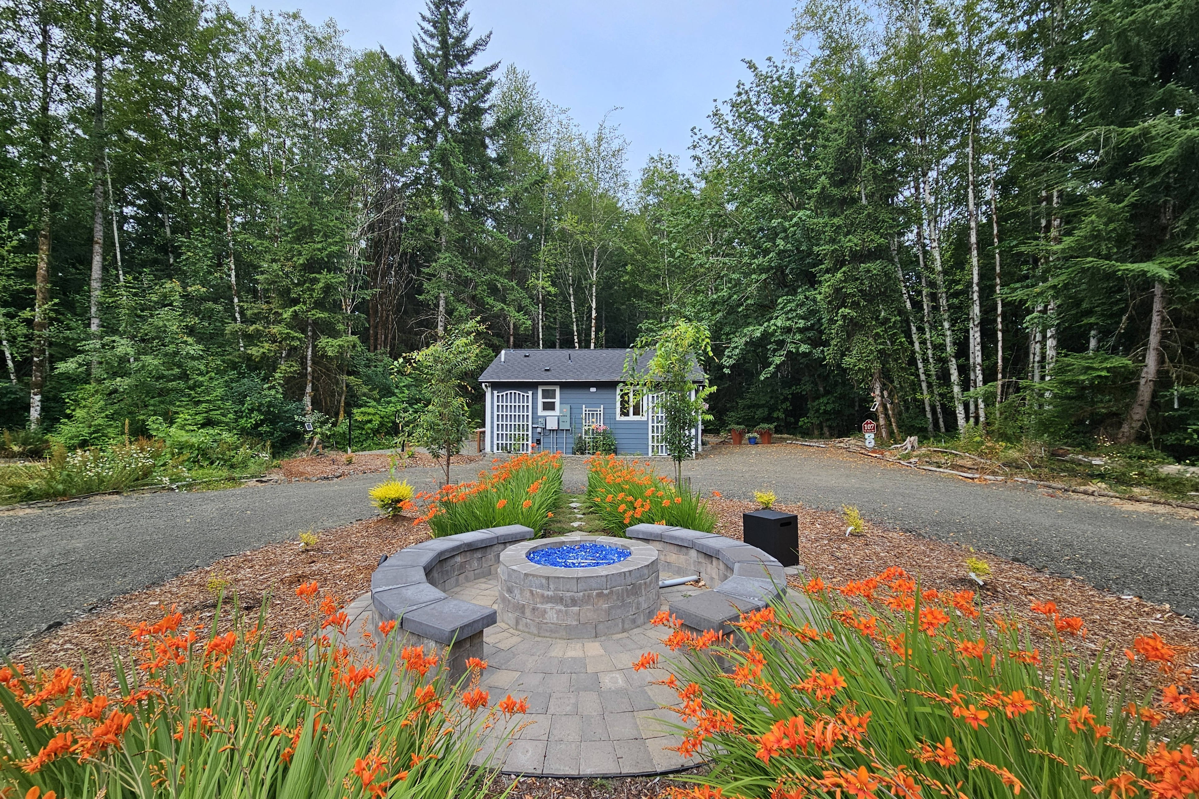 Propane fire pit and seating area between the 105-RV Site and 107-Cottage