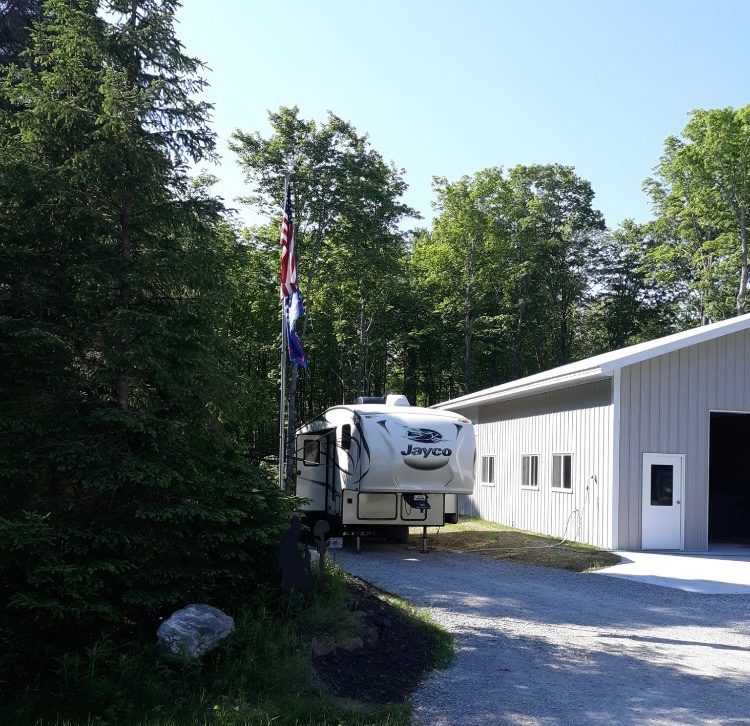 You will be backing up into site.  The water and electric are on side of building.  The sewer if toward the back of camper