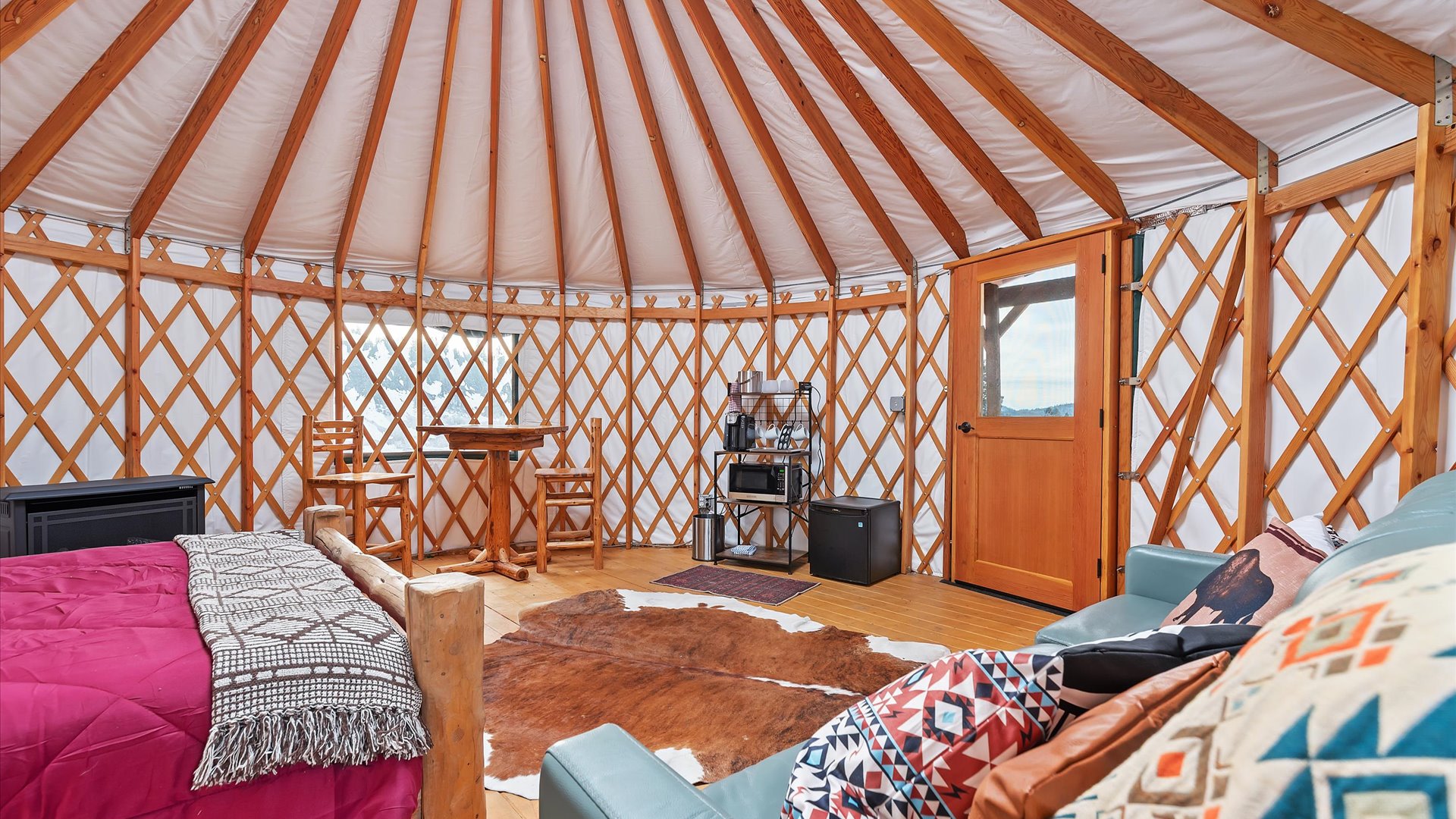 Gold Miner yurt interior with game table, coffee station and fridge.