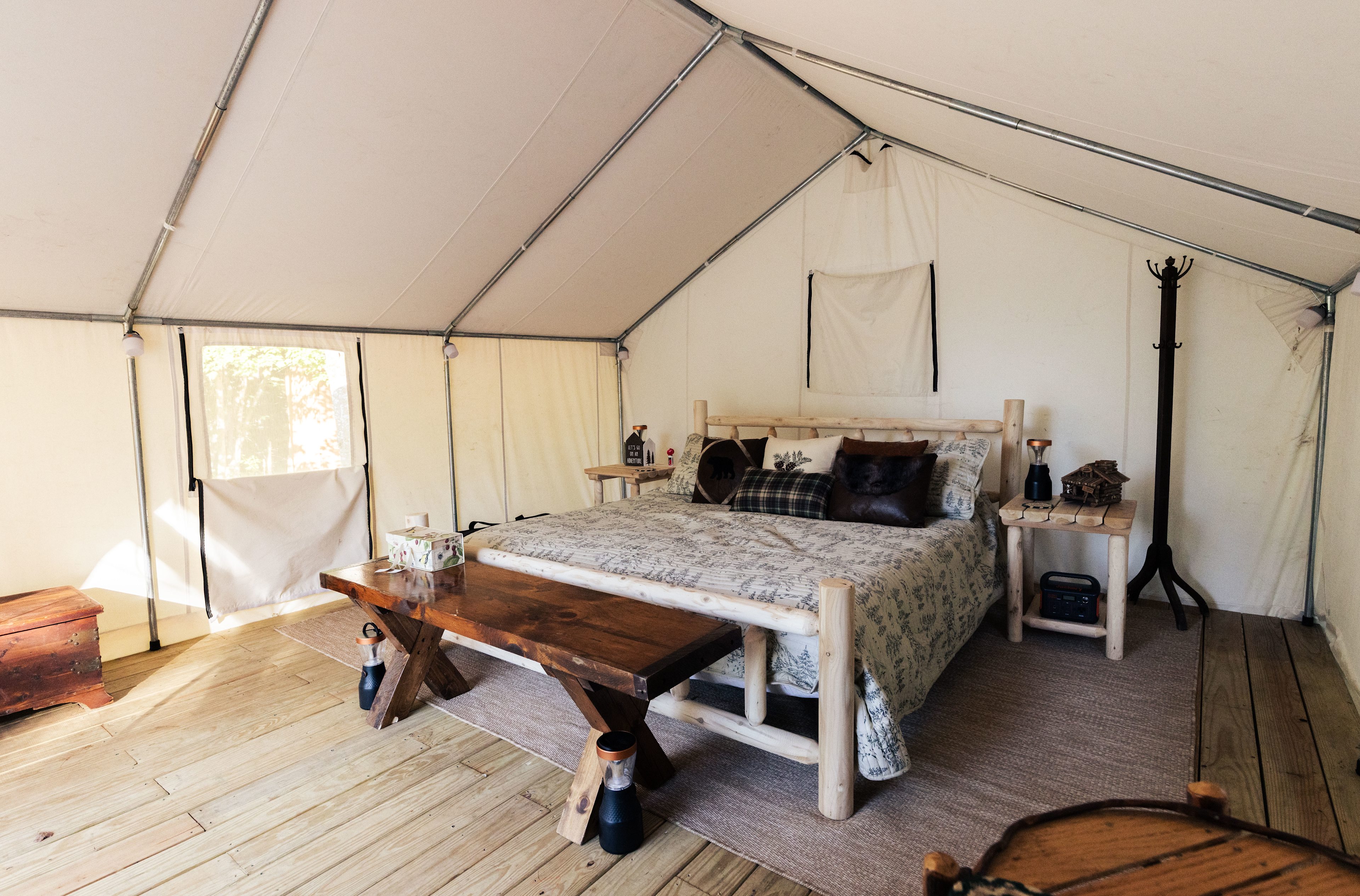 King sized bed inside the tent, with added seating, chairs, and jackery charging station
