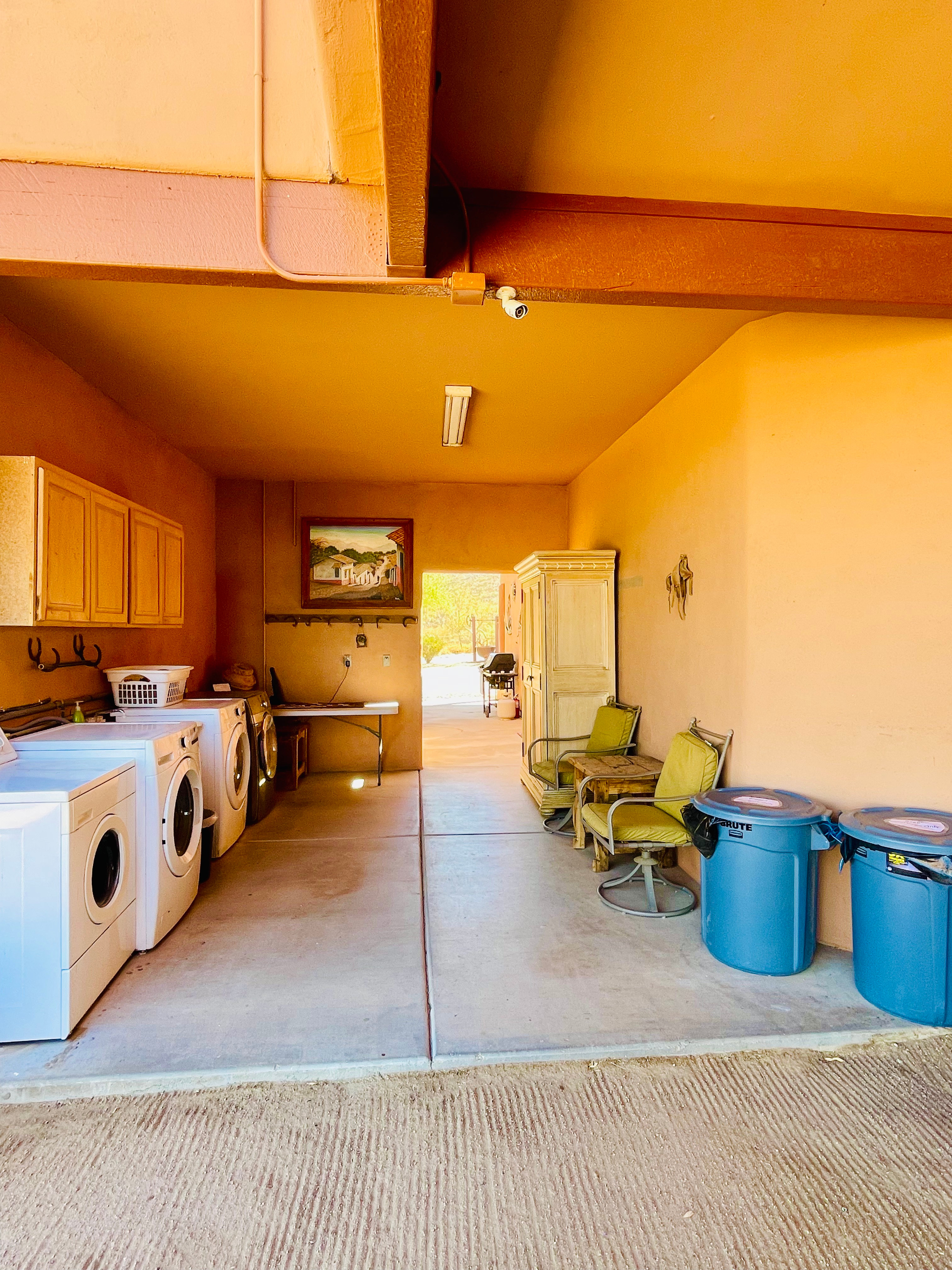 Laundry area. 2 washers(L) and 2 dryers(R). Laundry soap is provided and above dryers. Trash cans for bagged trash.