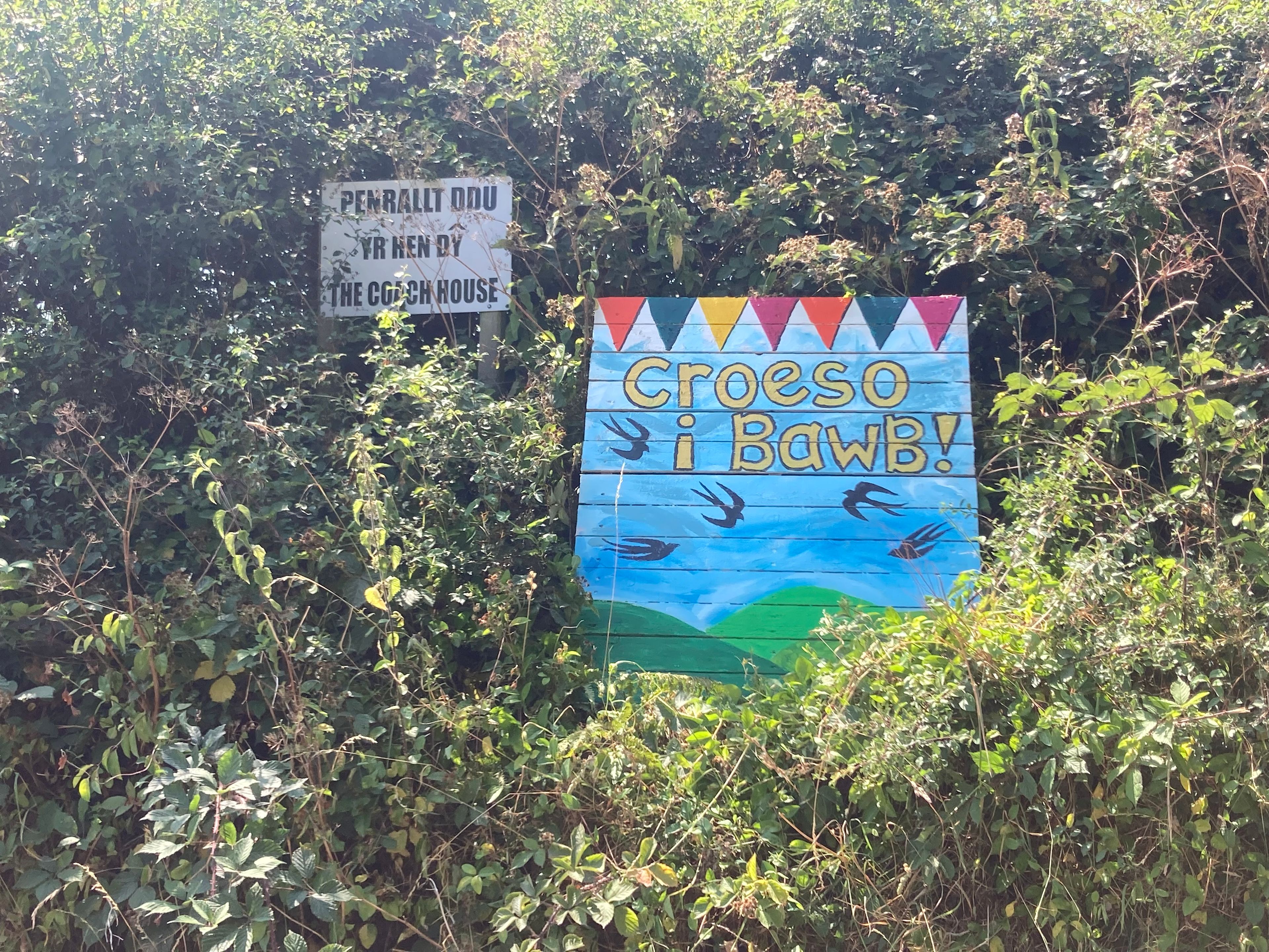 Entrance from road to farm track leading to Harbwr Cohousing and Maes Gwennol Camping