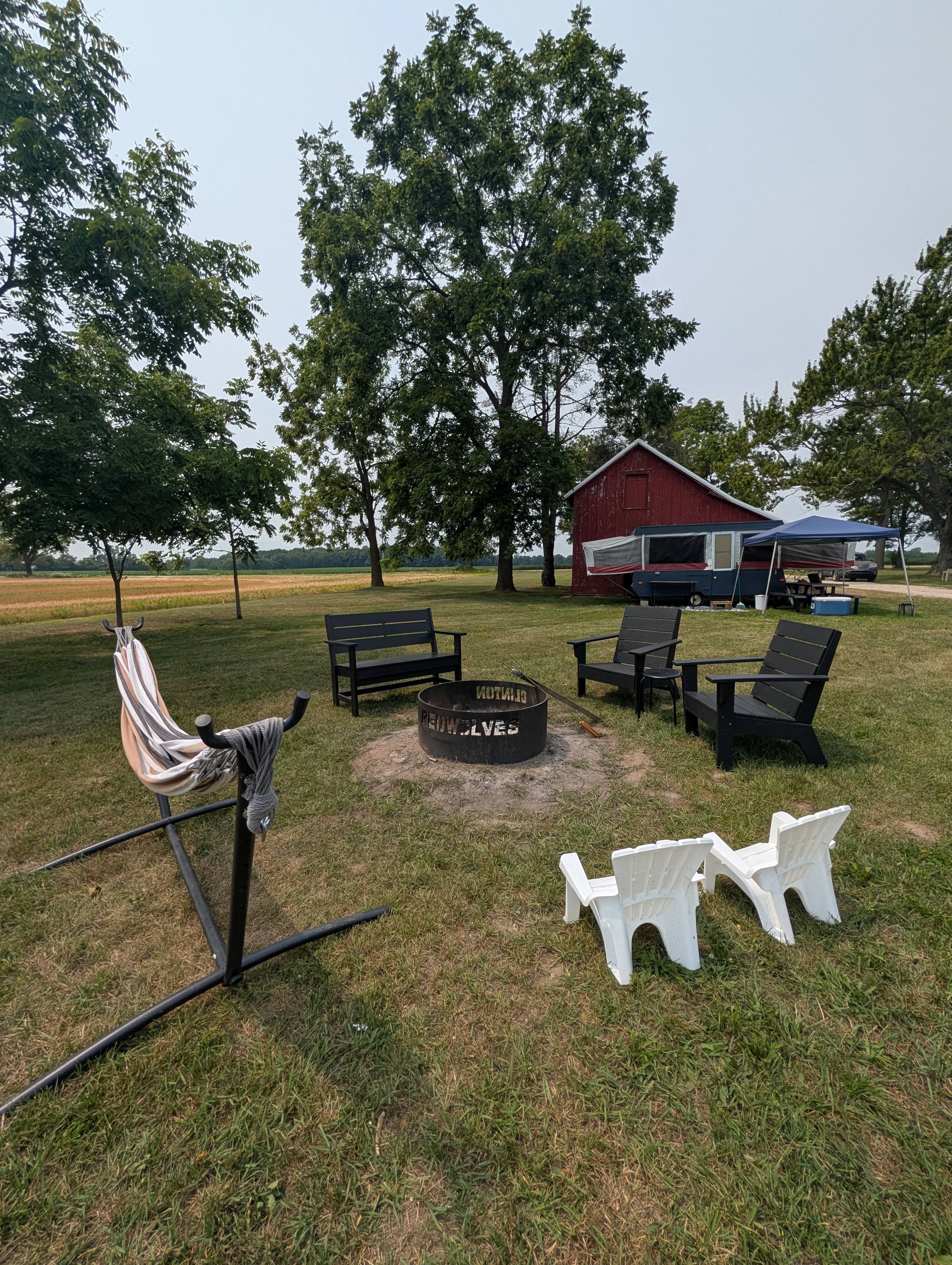 Fire pit,camper,tent and picnic table.