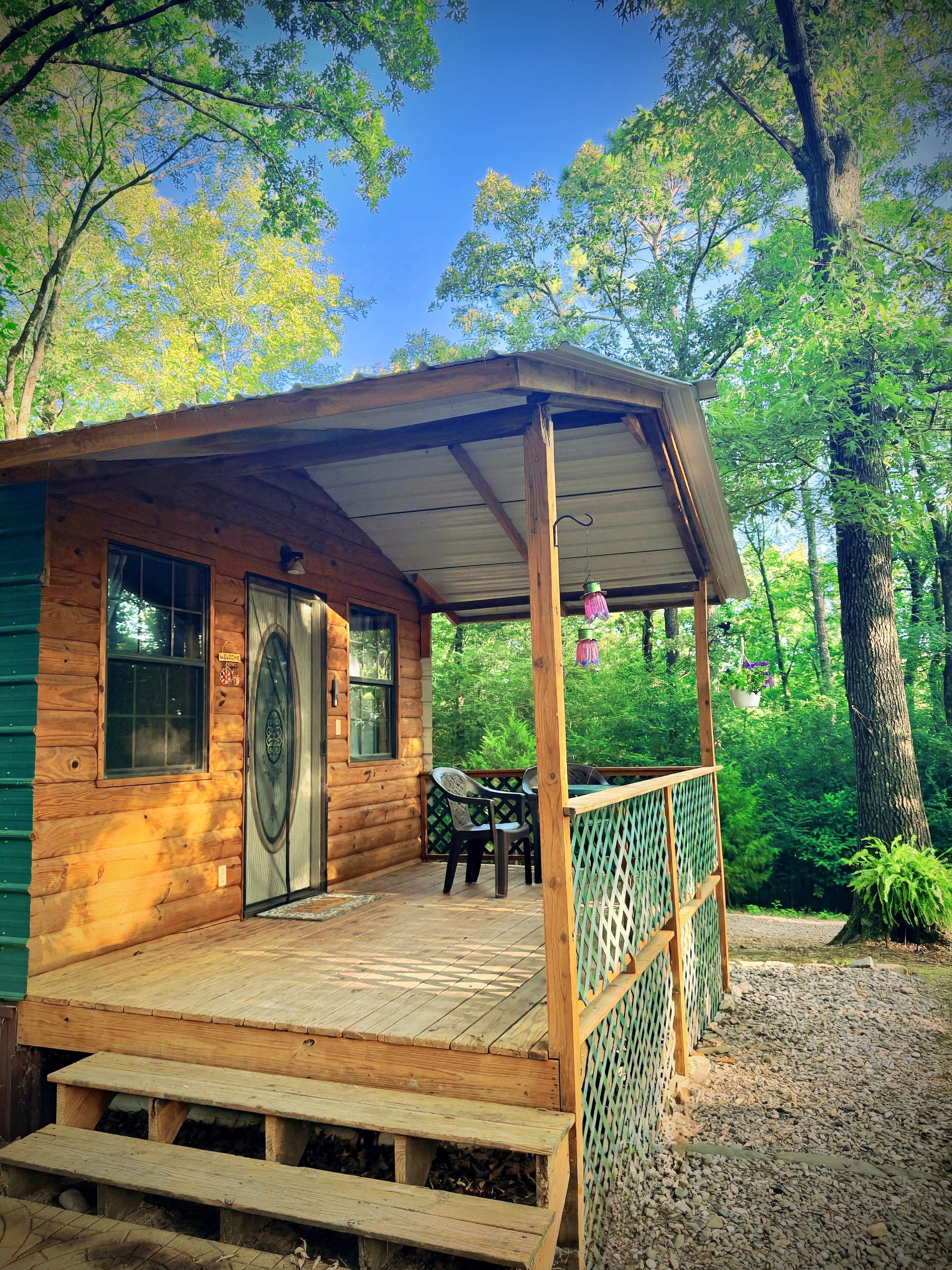 Relax on the covered porch whatever the time of day or the weather. With the woods surrounding, it's always shaded just the right amount